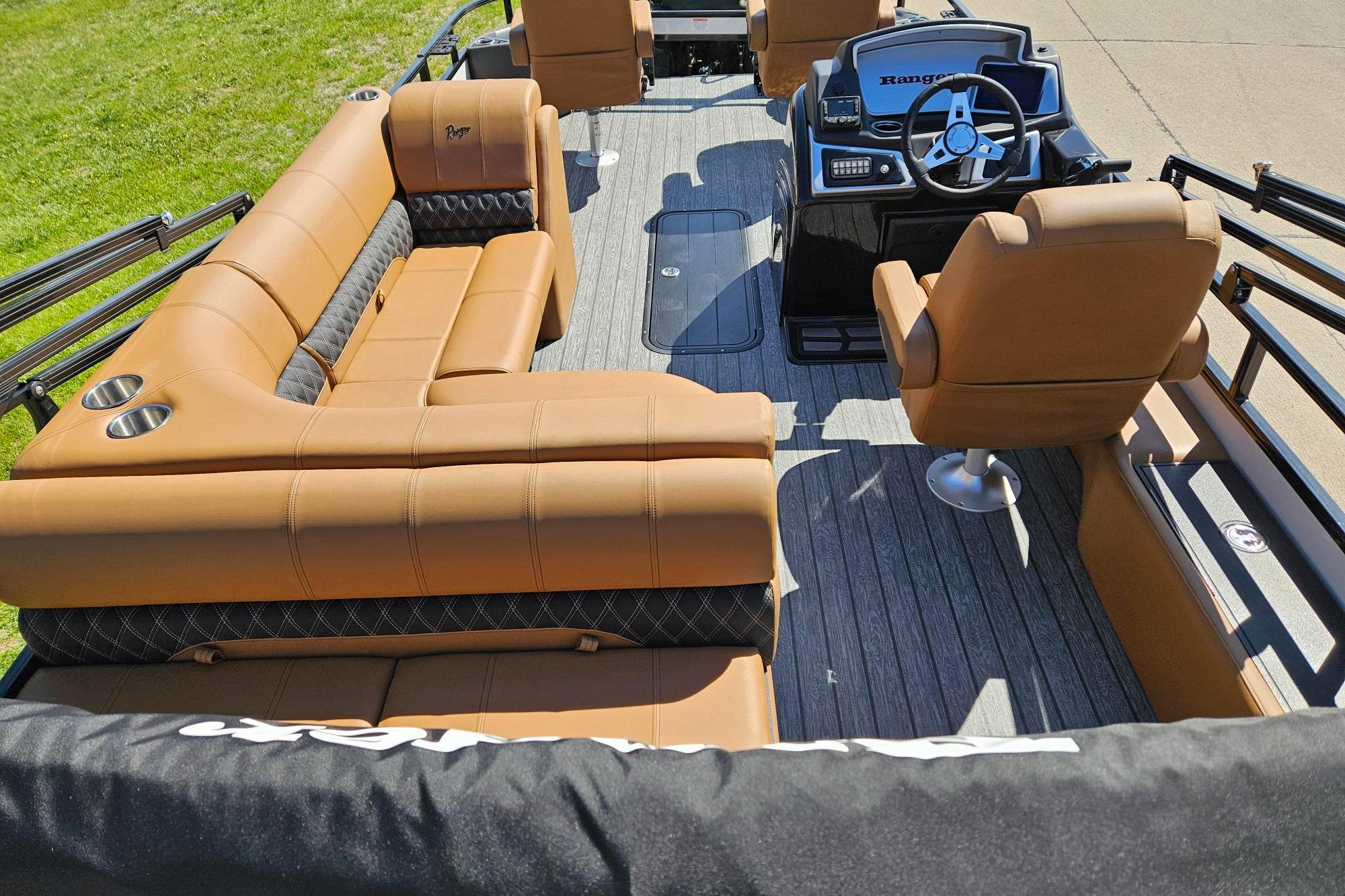 Luxurious interior of 2026 Ranger 223F boat with tan seating and modern steering console.
