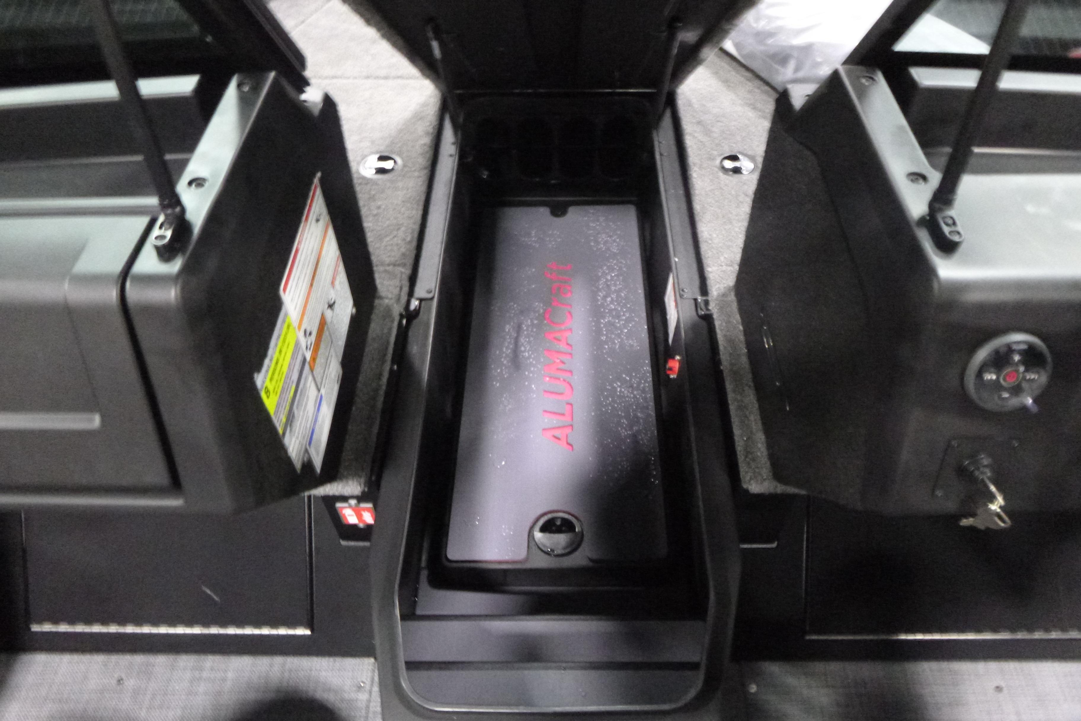 2026 Alumacraft Trophy 205X Sport interior storage compartment with open hatches.