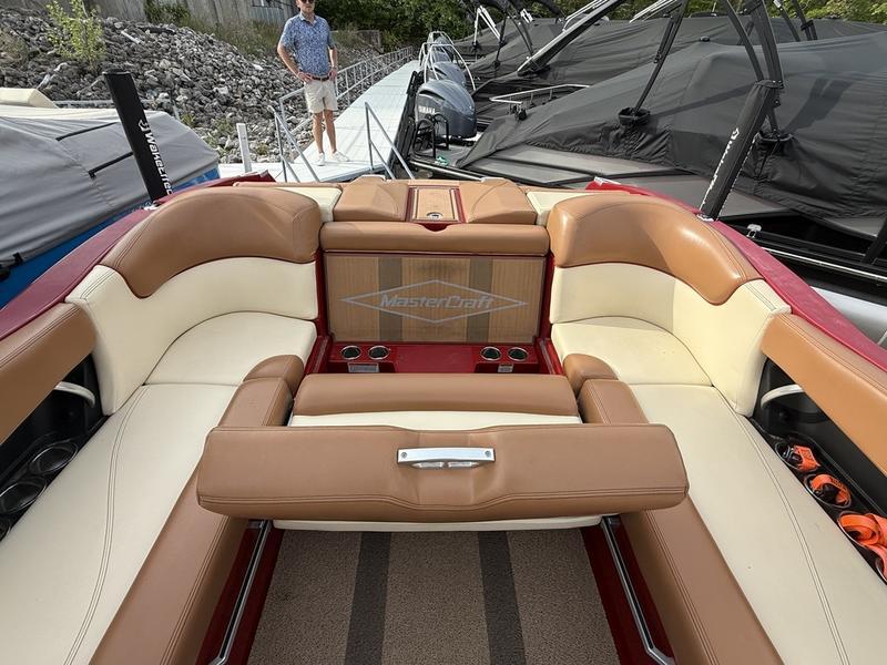 2016 MasterCraft X23 boat interior with tan and cream seating, docked near other boats.