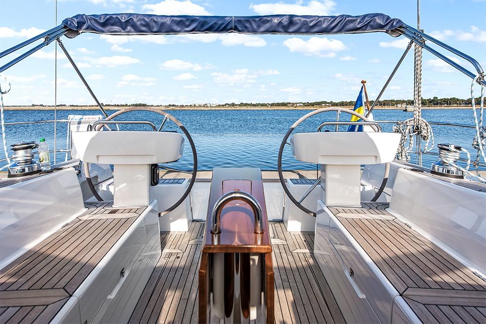 2022 Hallberg-Rassy 400 yacht cockpit with dual steering wheels and scenic ocean view.