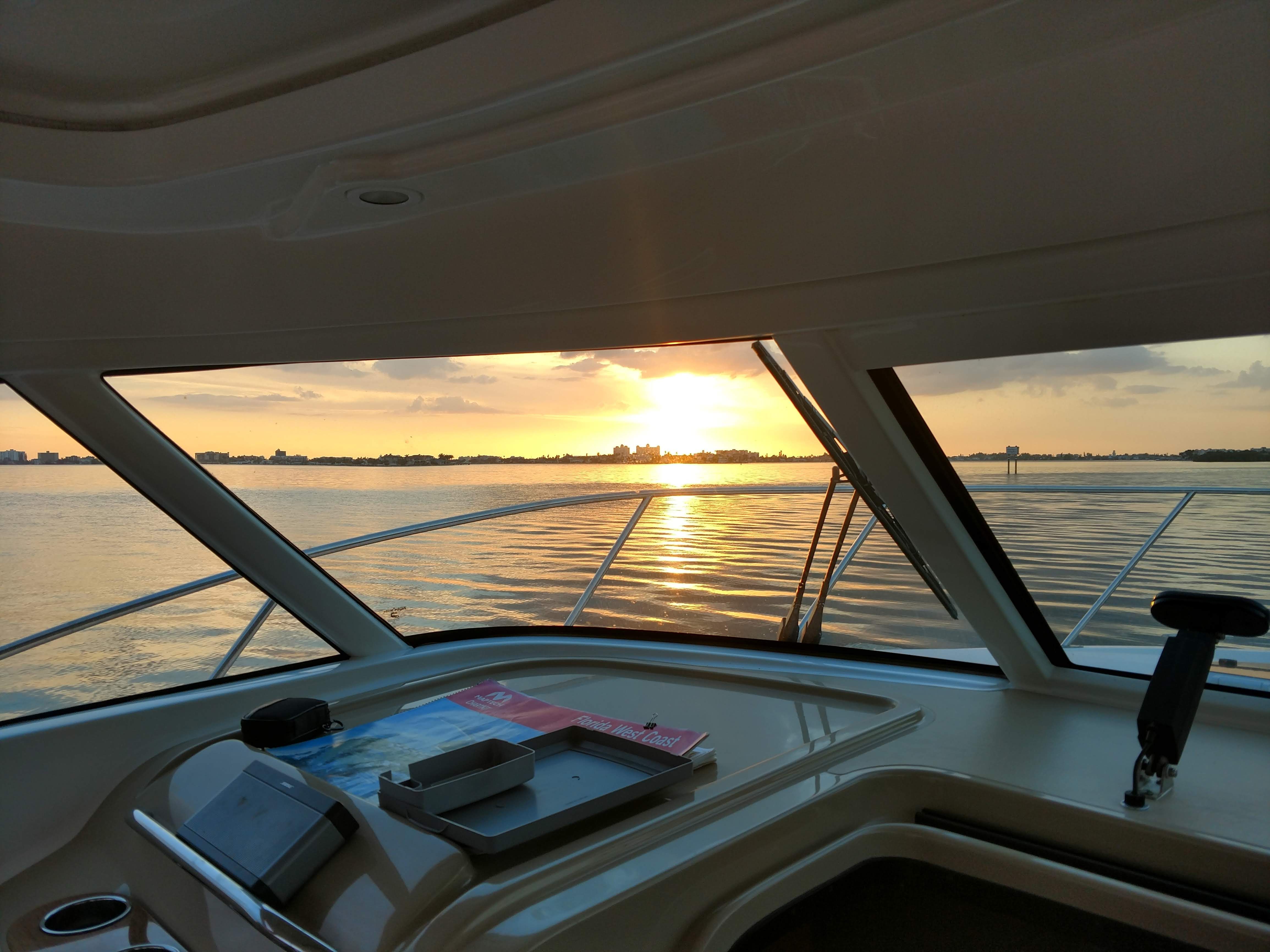 View from inside a Tiara Yachts 3100 Coronet, looking at a sunset over the water.