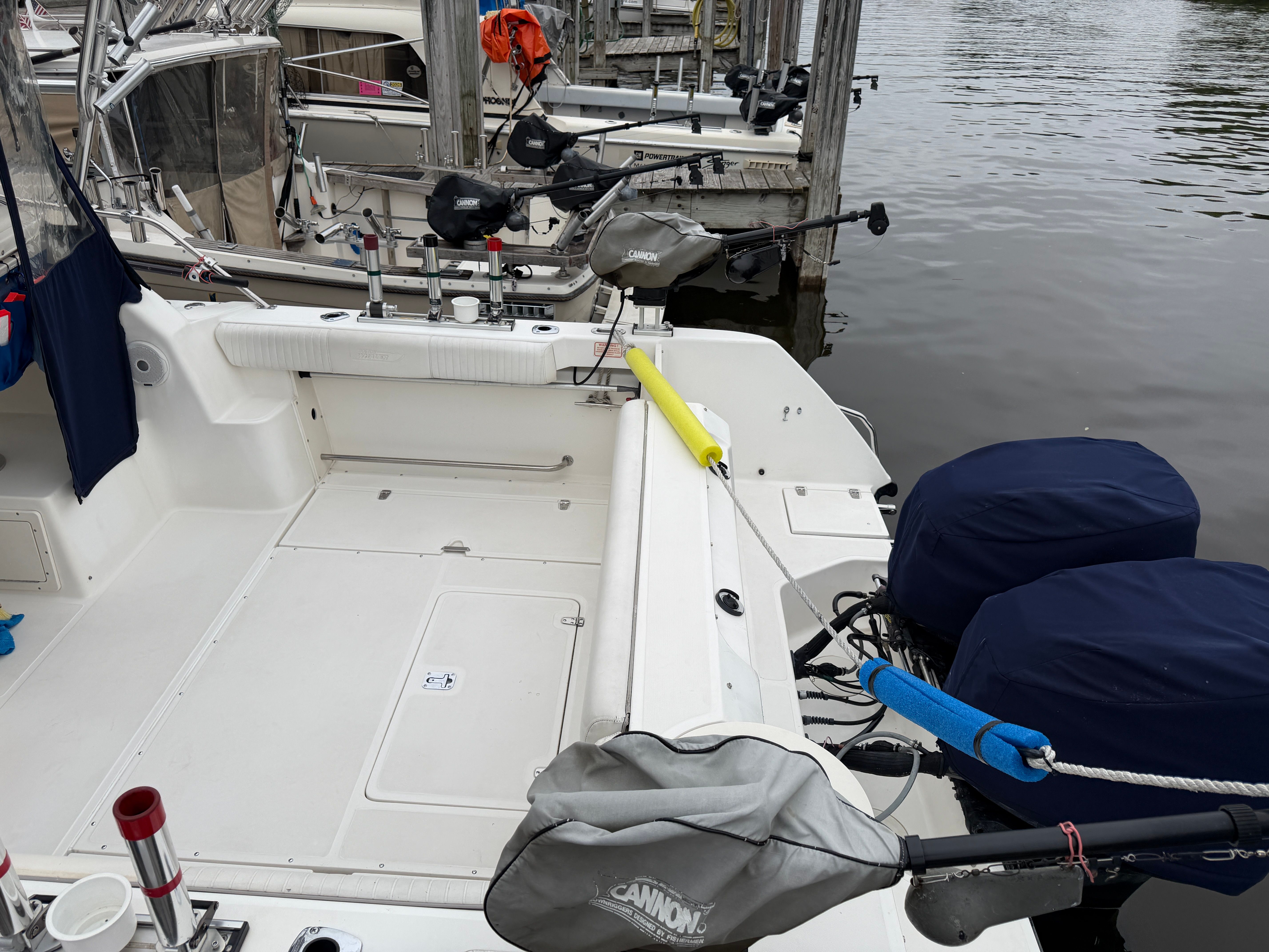 The image shows the stern of a 2001 Boston Whaler 26 Conquest boat docked at a pier.