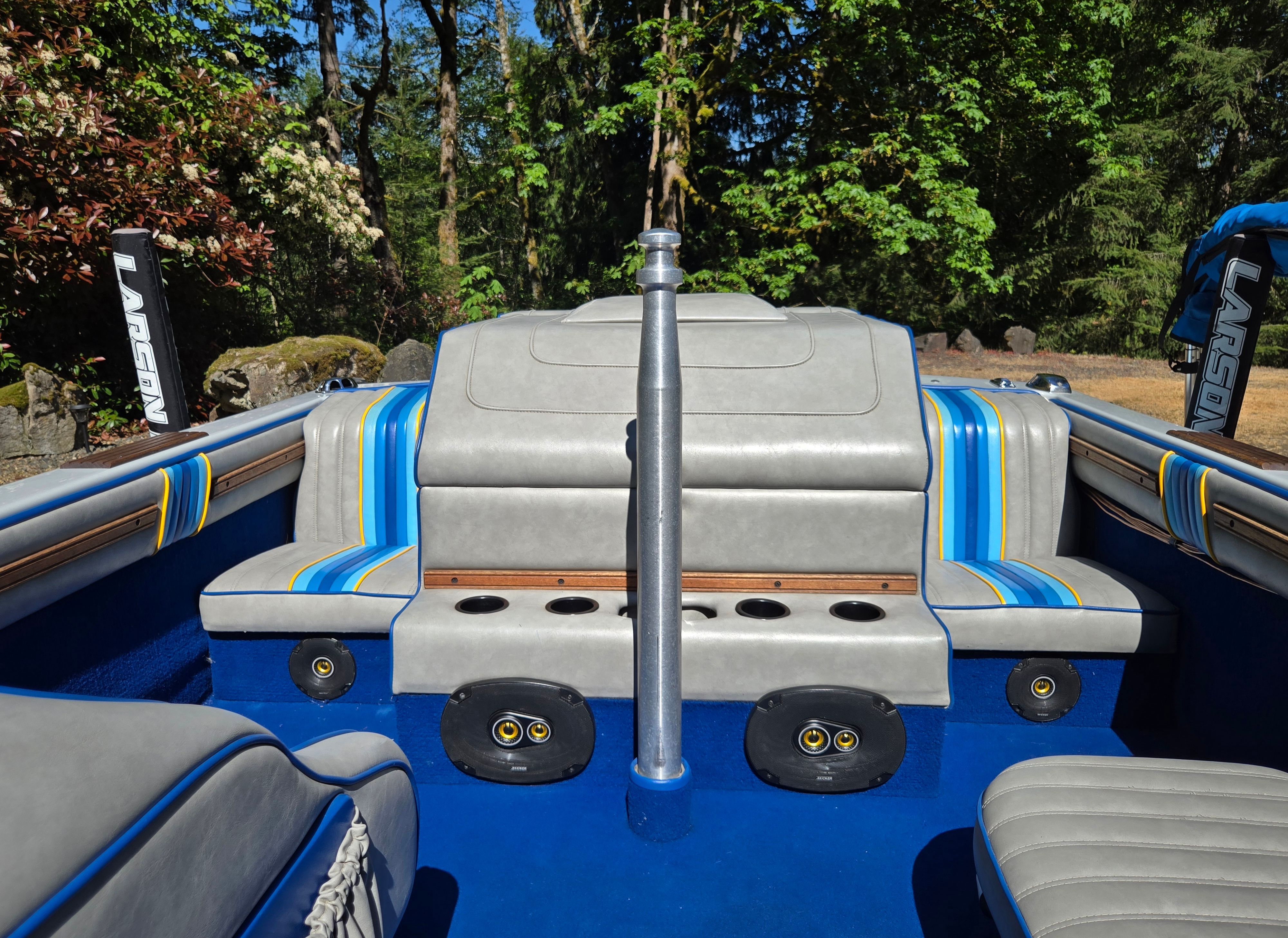 Interior view of a 1990 Sanger Ski Sanger with blue and gray seating outdoors.