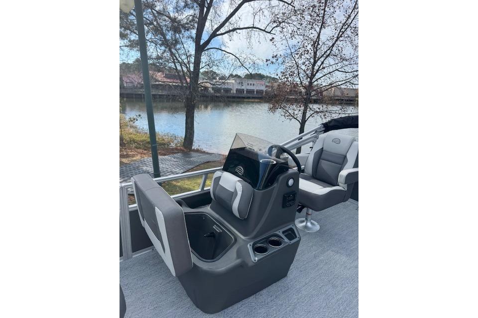 2026 Sun Tracker Bass Buggy 16 XL Select pontoon boat interior by a serene lake.