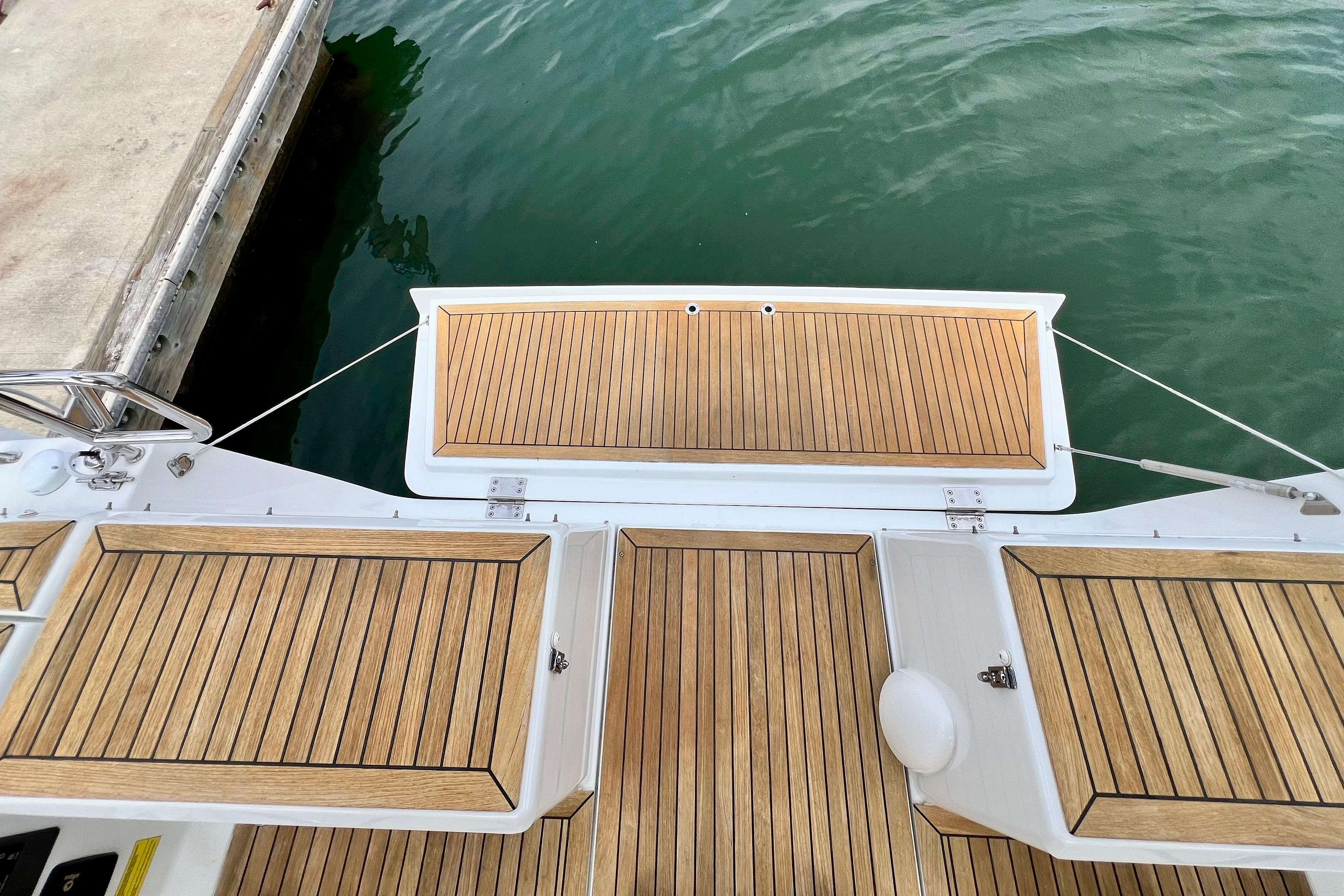 Teak deck of 2016 Hanse 455 yacht at marina, showcasing elegant wood finish.