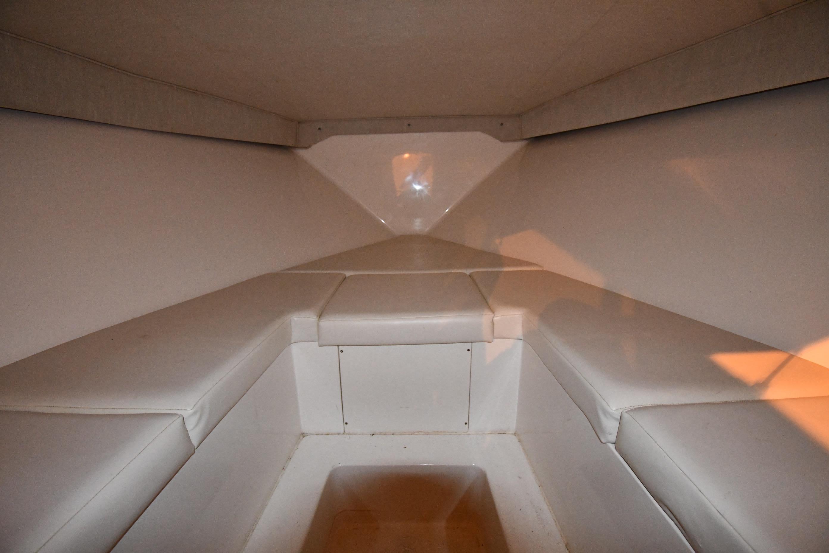 Interior cabin of a 2001 Fountain 38 Center Console boat, featuring white cushioned seating.