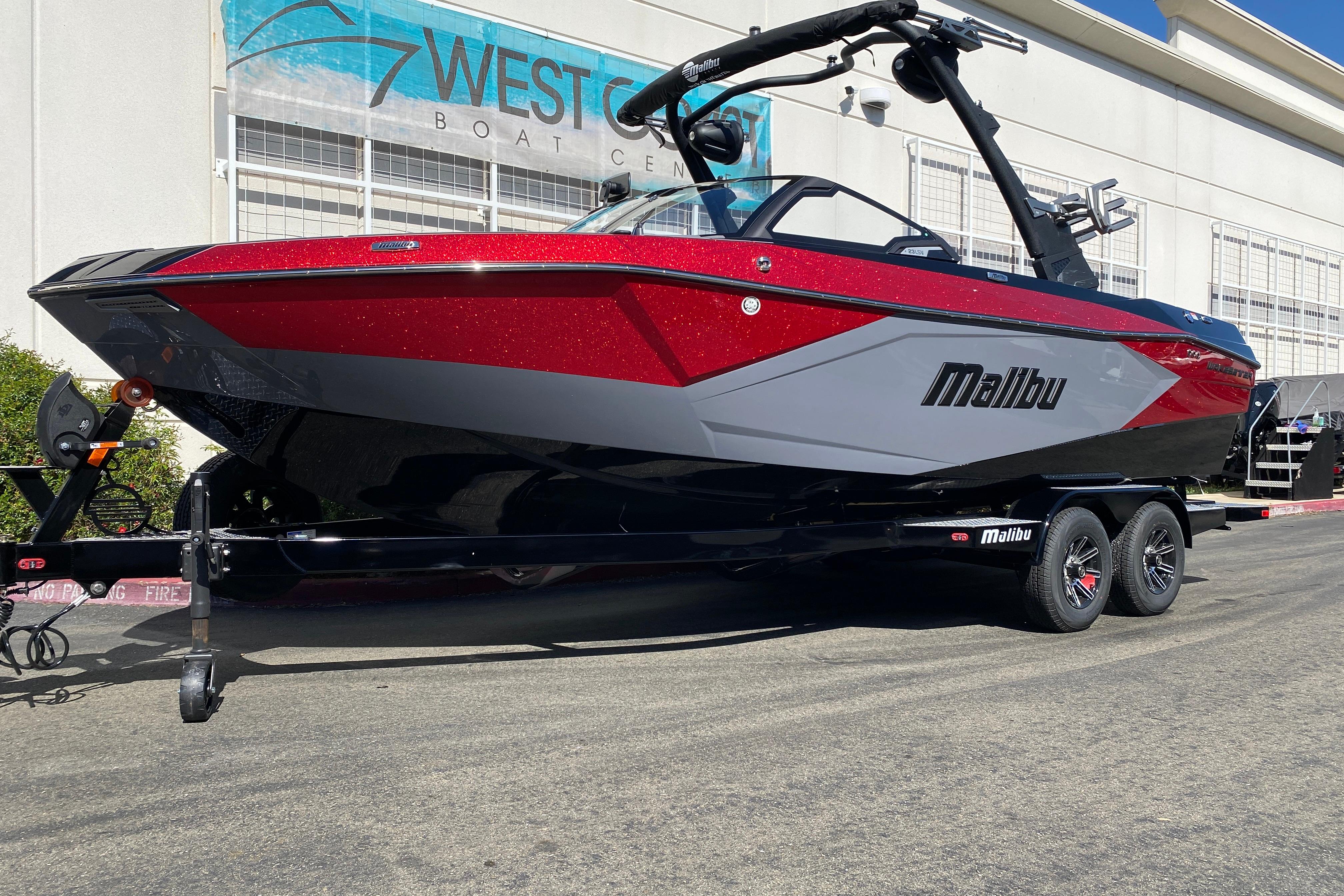 2025 Malibu Wakesetter 23 LSV boat in red and gray, parked at West Coast Boat Center.