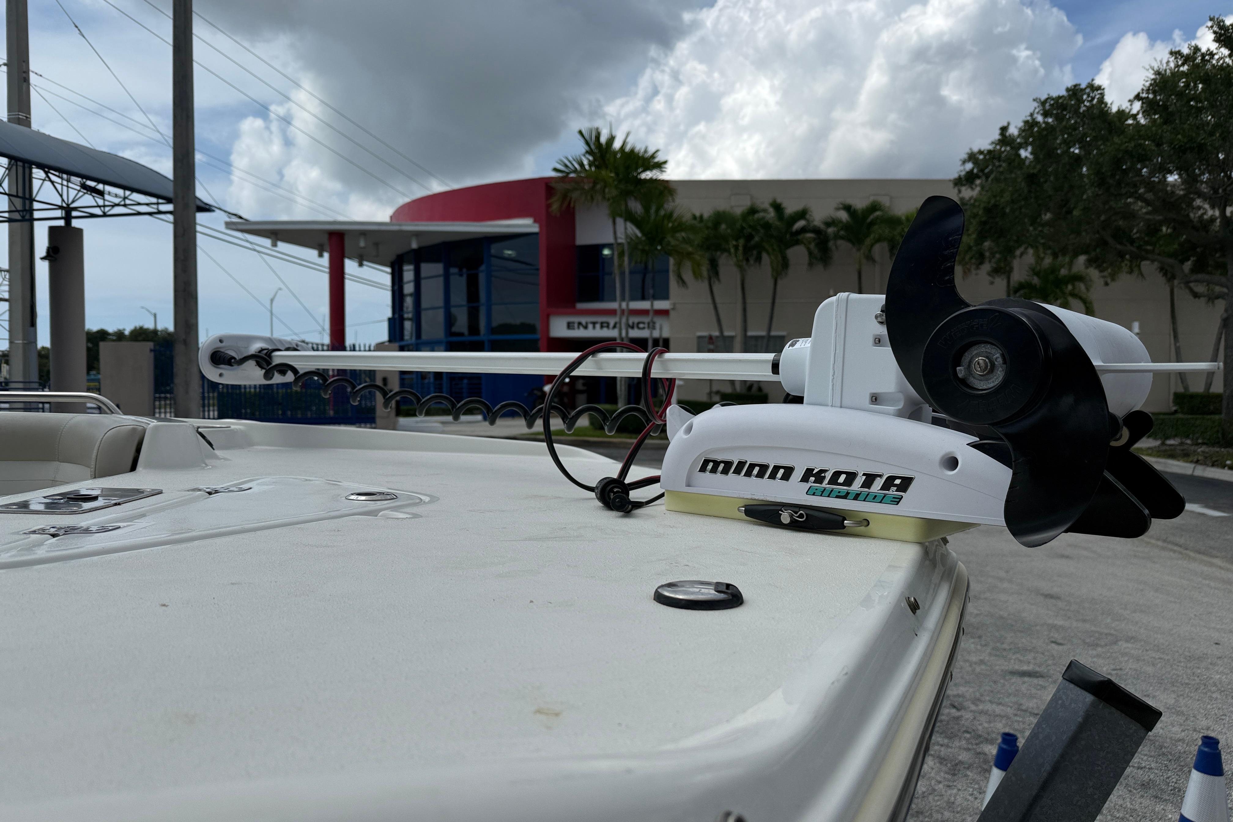 2015 NauticStar 231 Coastal boat with Minn Kota trolling motor, parked outdoors.