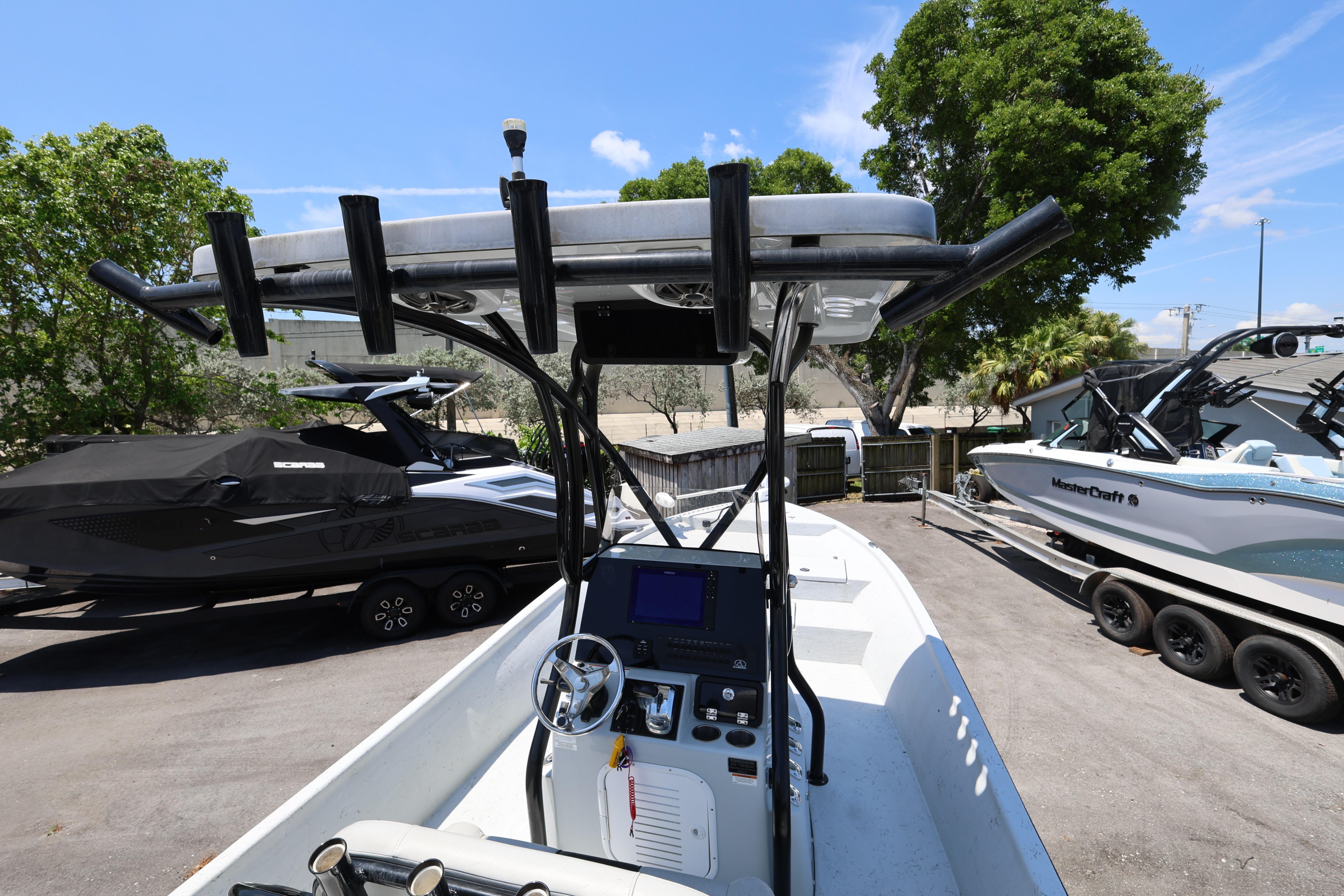 2021 Blazer Bay 2400 boat with T-top, parked alongside other boats in a sunny marina.