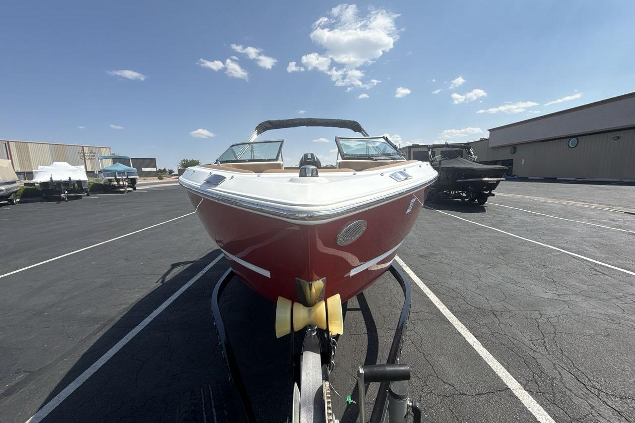 2024 Four Winns H1 OB boat on trailer, parked outdoors under a clear sky.