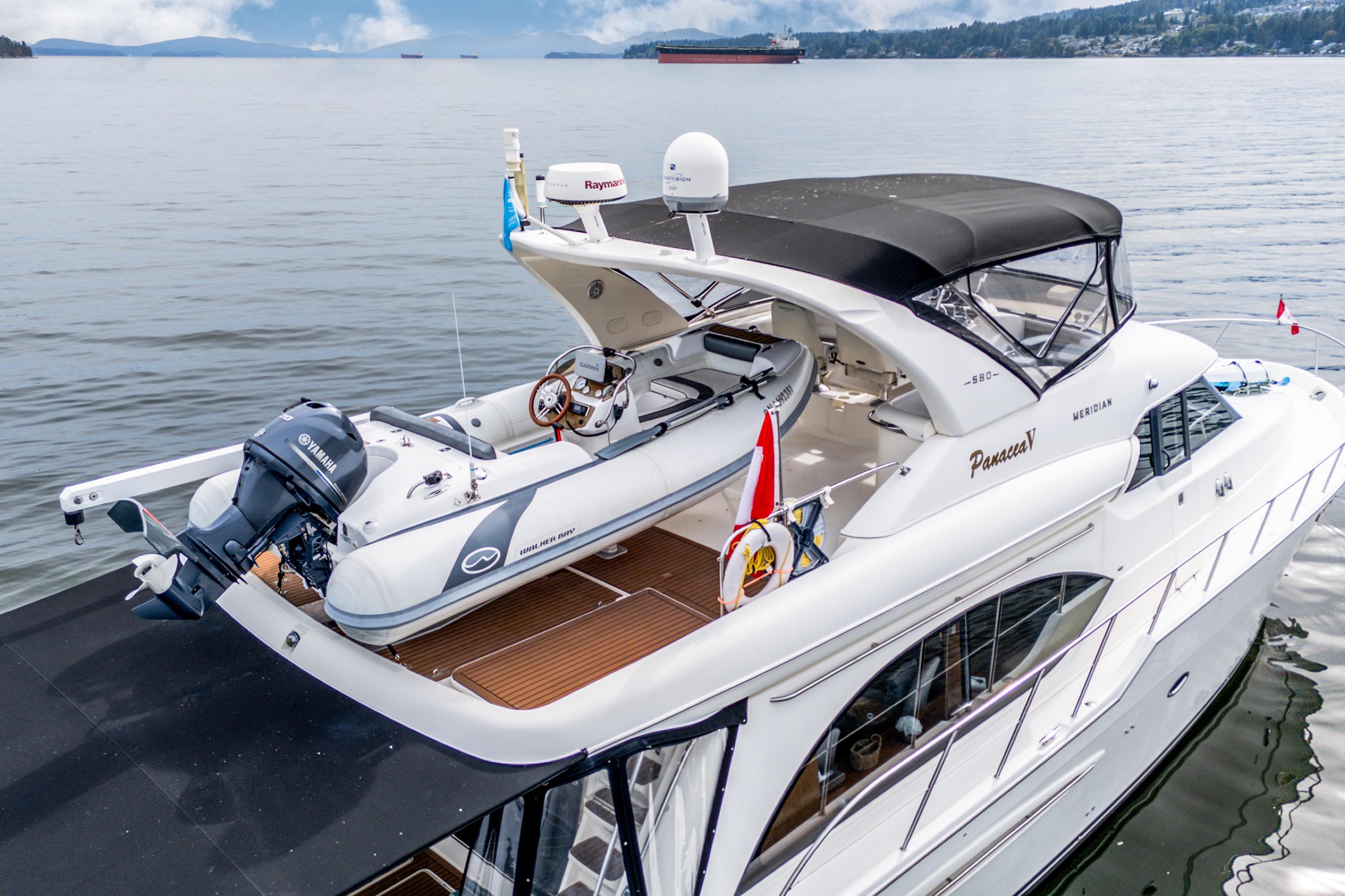 2007 Meridian 580 Pilothouse yacht with tender on deck, cruising on calm waters.