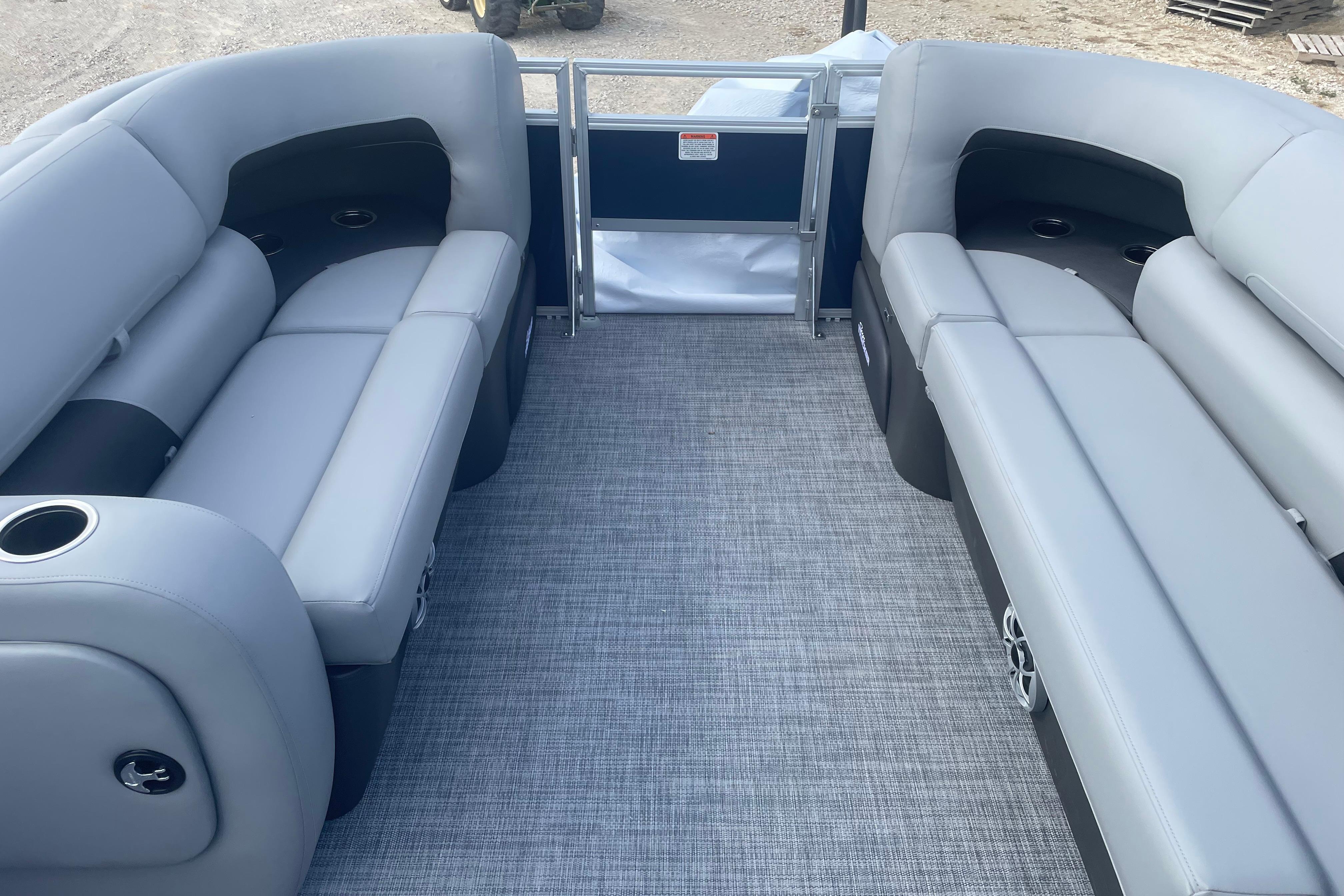 2026 Sun Tracker SportFish 22 DLX pontoon boat interior with gray seating and carpet.