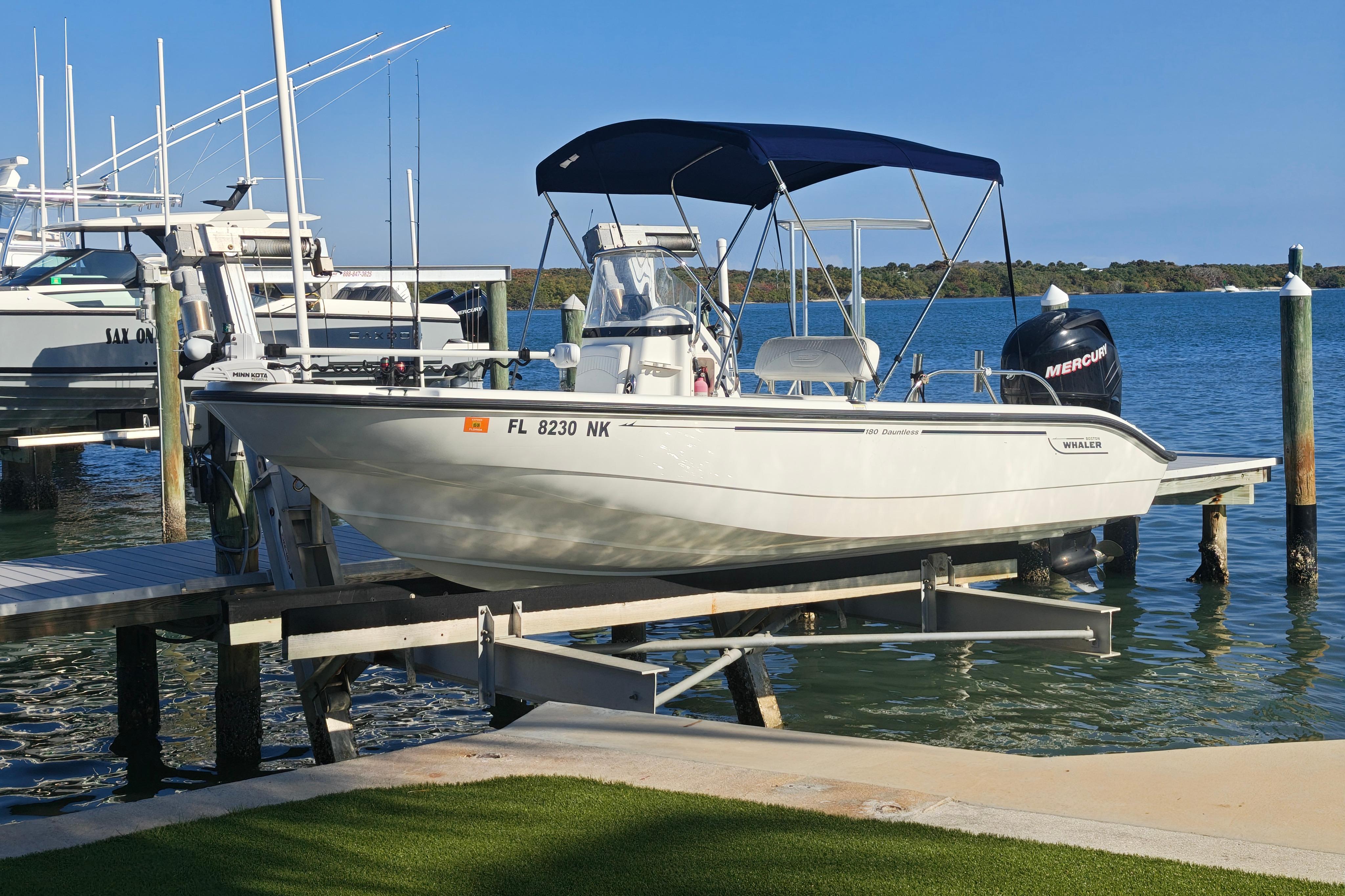 2006 Boston Whaler 180 Dauntless boat docked by the water with a Mercury engine.