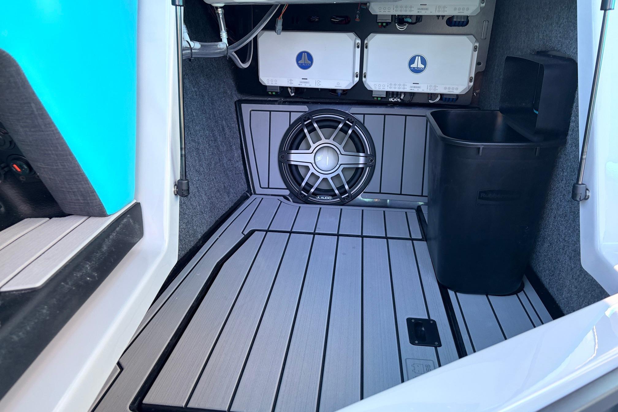 2026 Nautique Super Air Nautique G23 interior with subwoofer and storage compartment.
