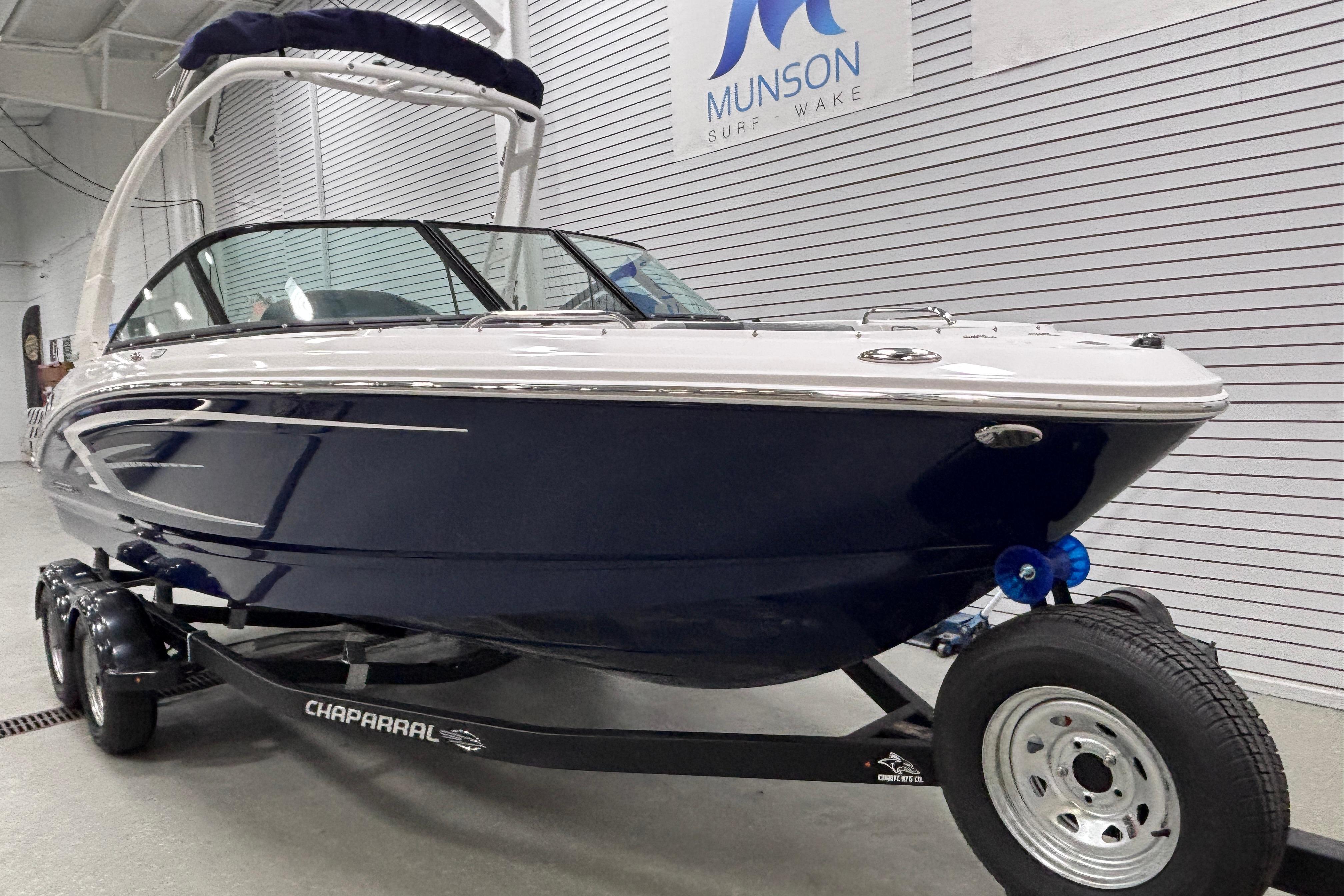 2026 Chaparral 21 SSi boat on trailer in showroom, Munson Surf Wake sign visible.