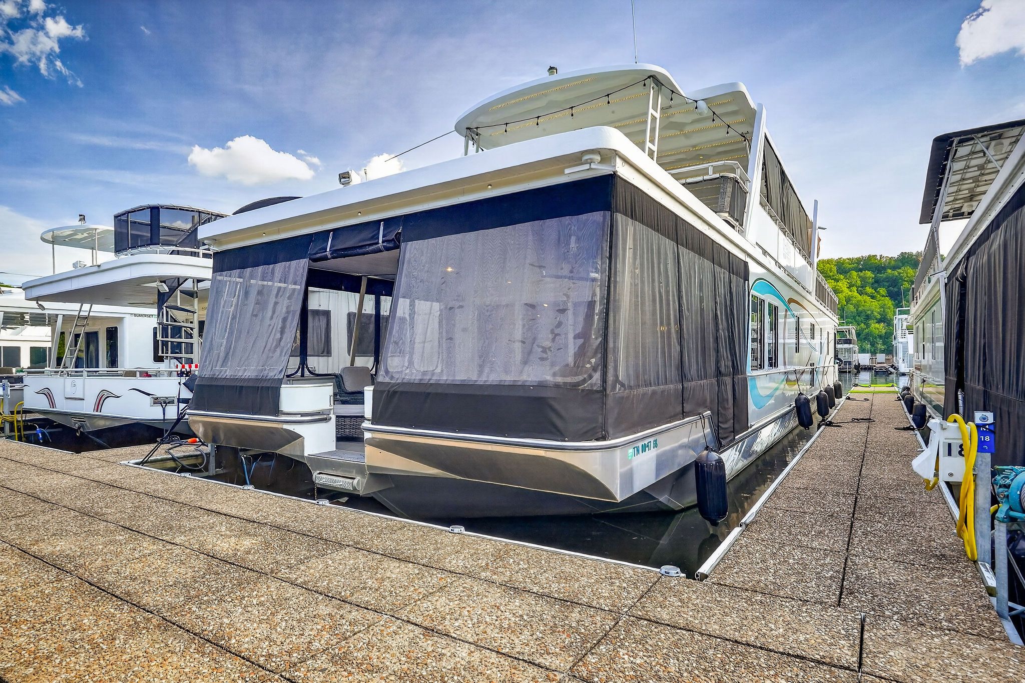 2010 Houseboat Thoroughbred docked under blue sky.