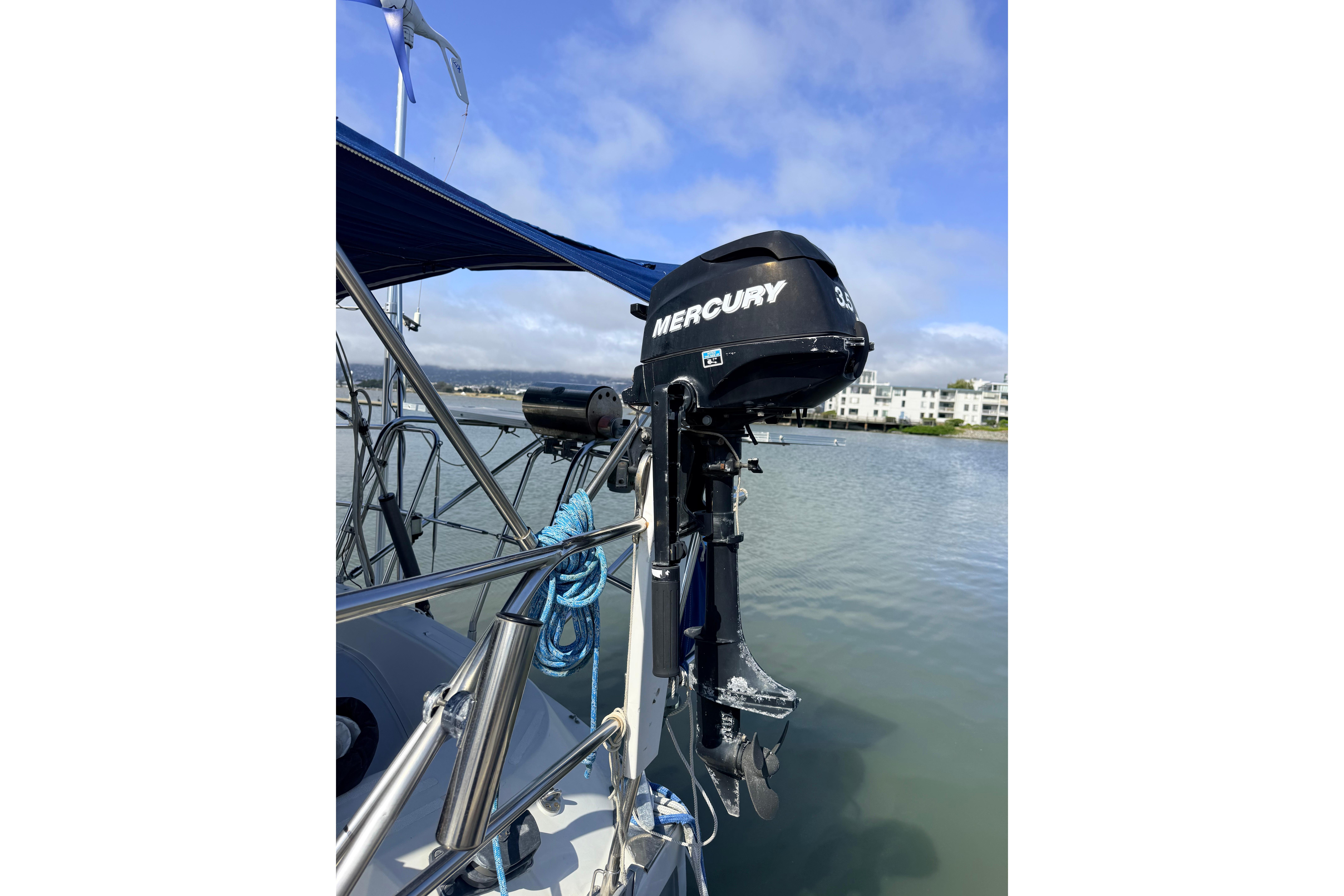 Outboard motor on 1987 Norseman 400 sailboat, docked by calm waters.