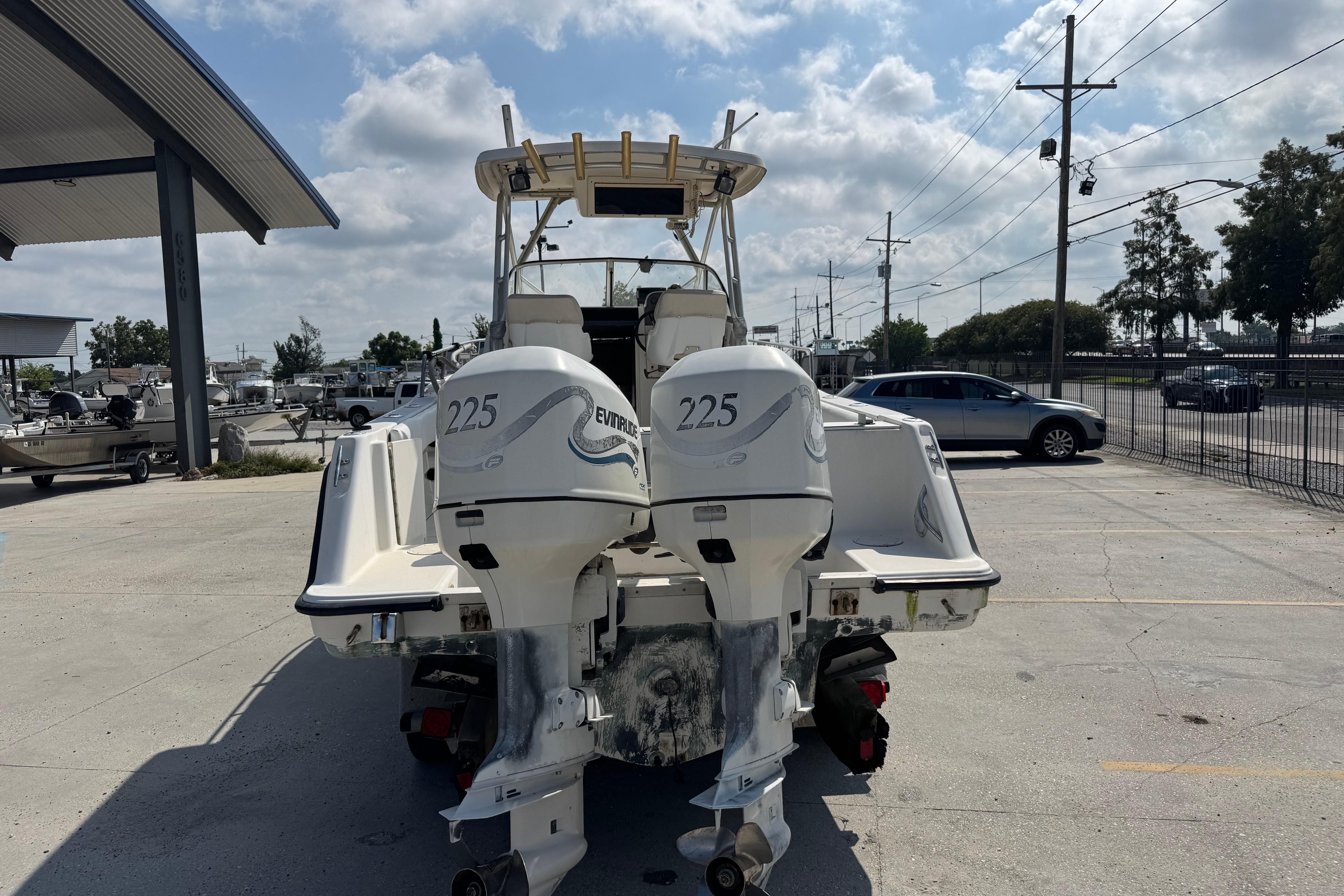 1997 Hydra-Sports VECTOR 2650 WA boat with dual Evinrude 225 engines, parked outdoors.