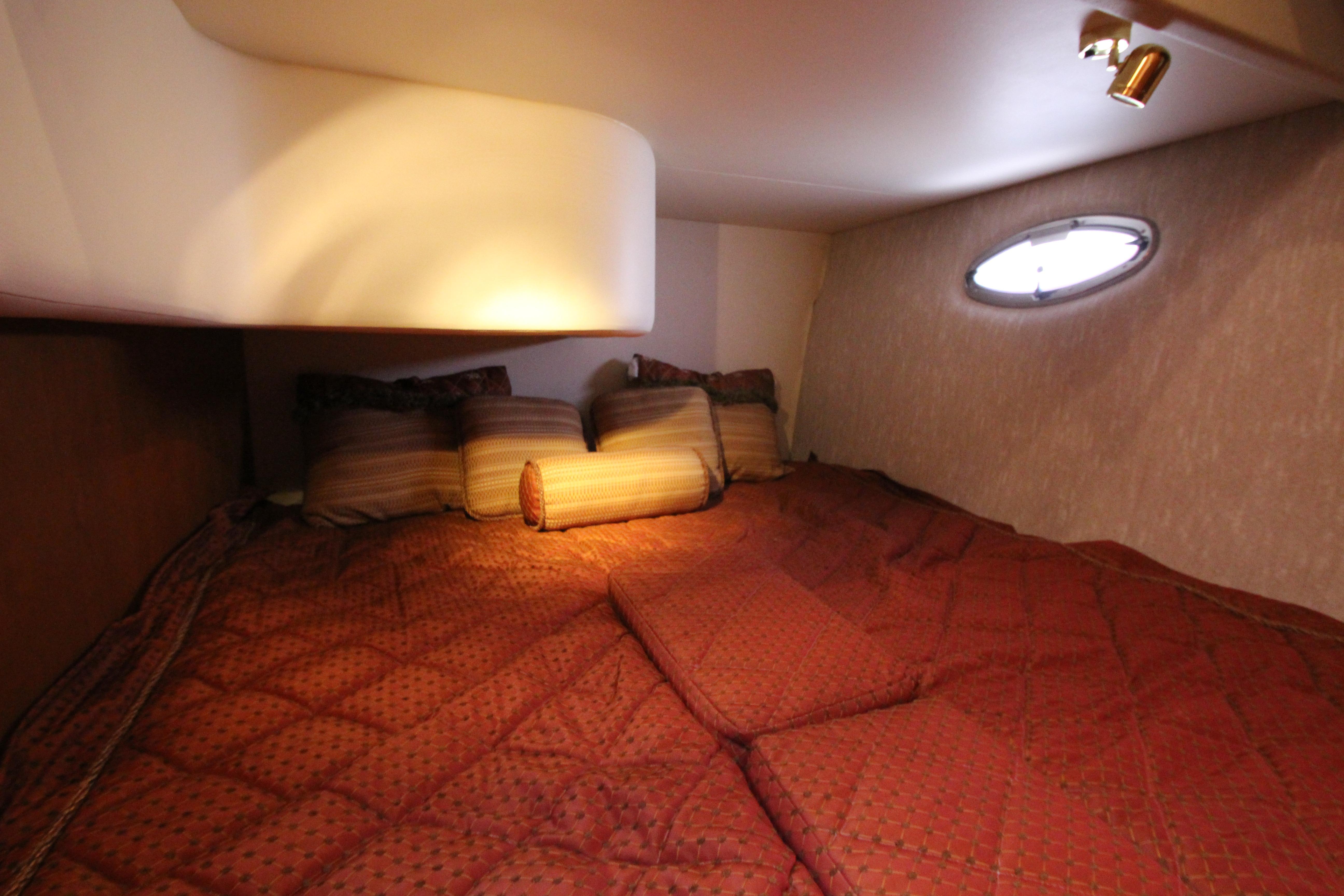 Cozy cabin interior of 2006 Silverton 38 Sport Bridge with plush bedding and soft lighting.