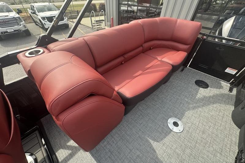 Red leather seating on 2026 Regency 230 DL boat, featuring cup holder and carpeted floor.