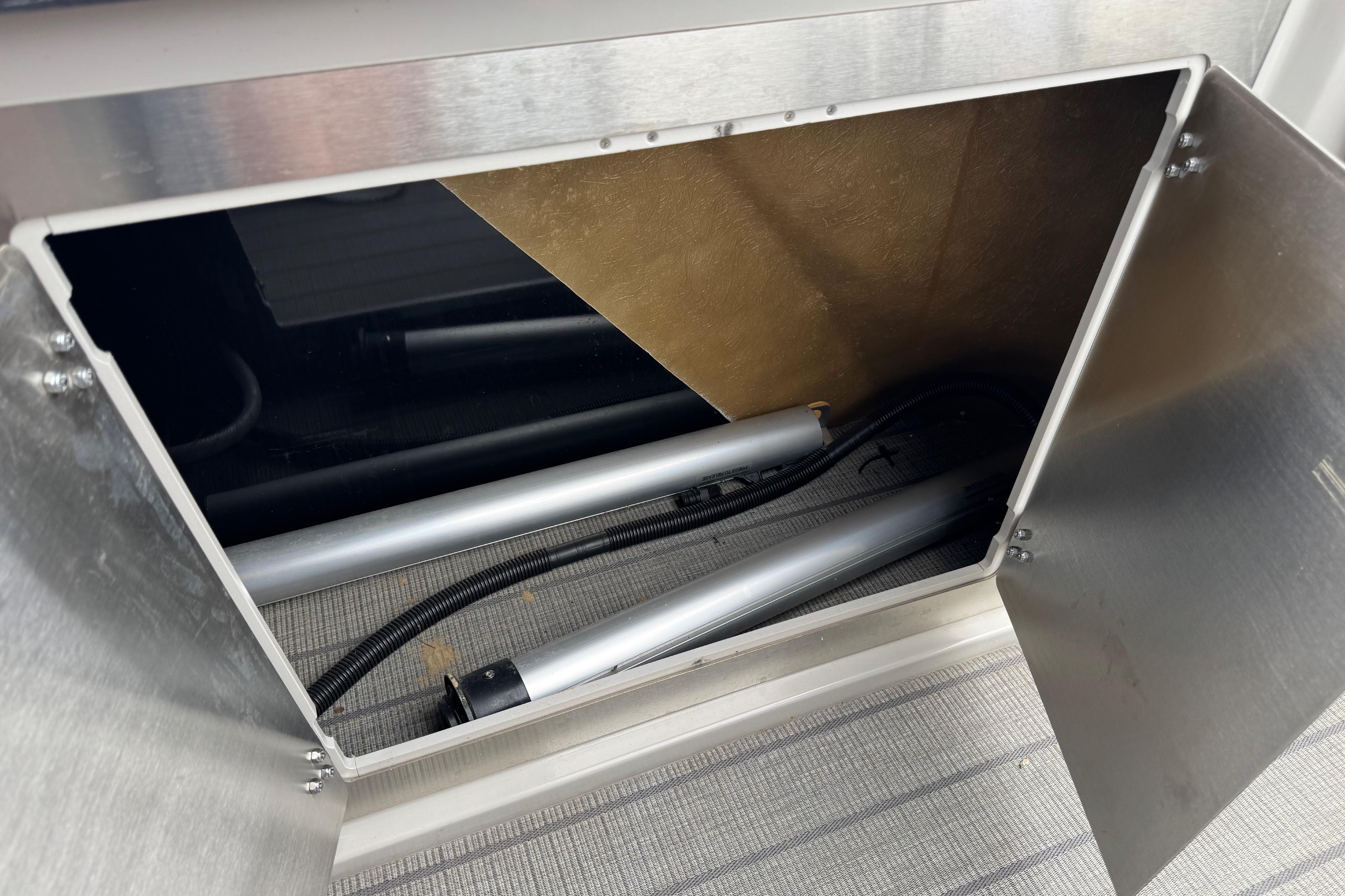 Open storage compartment in 2023 Starcraft MX 25 DL DH boat, showing interior components.