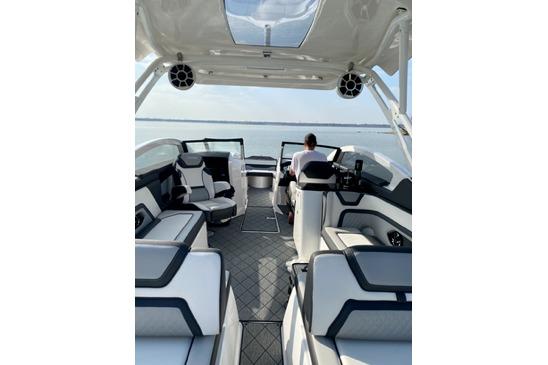 Luxurious 2021 Yamaha Boats 275SD interior with modern seating and helm on open water.