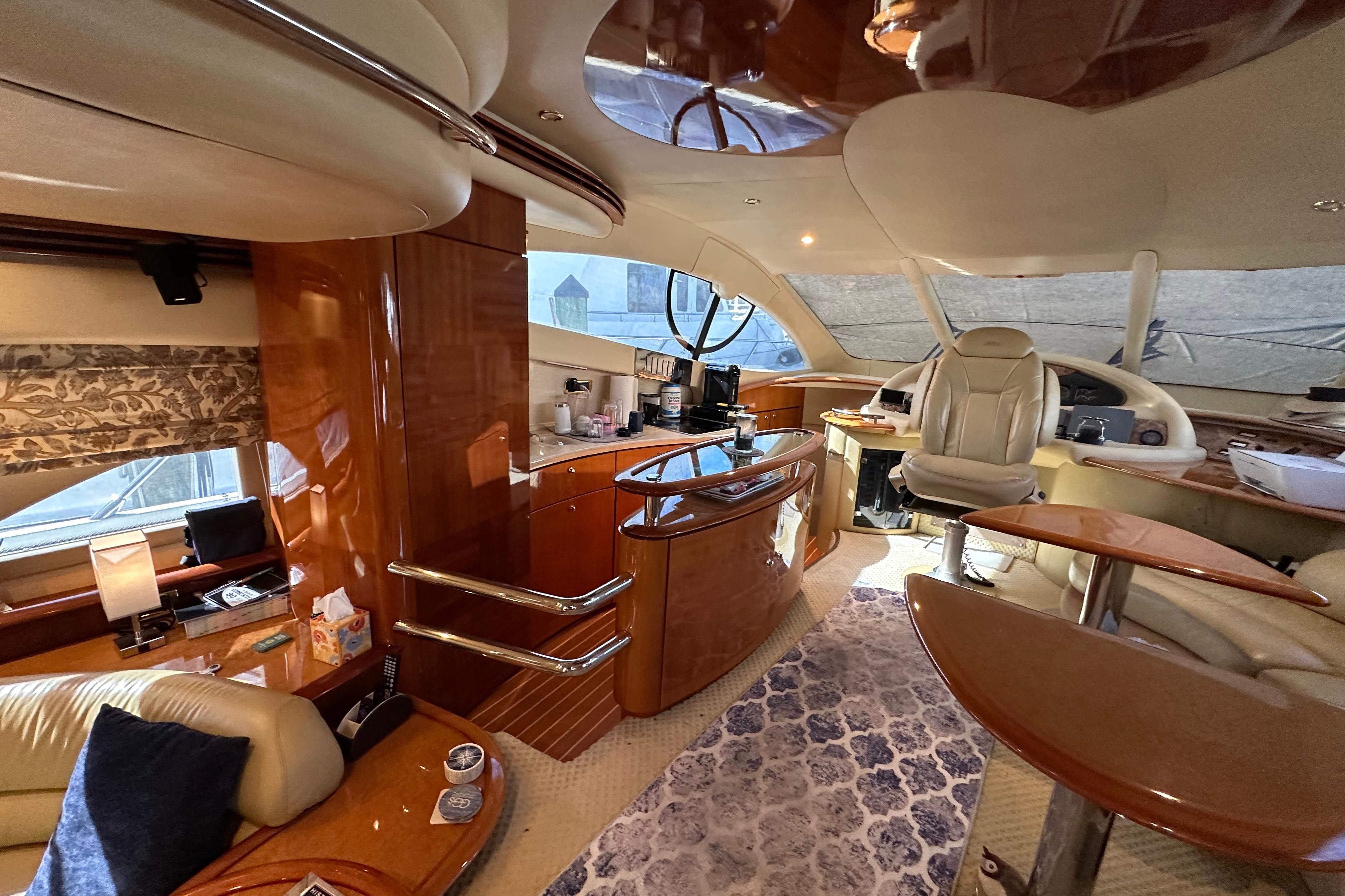 Luxurious interior of a 2004 Azimut 55E yacht with elegant wood finishes and plush seating.
