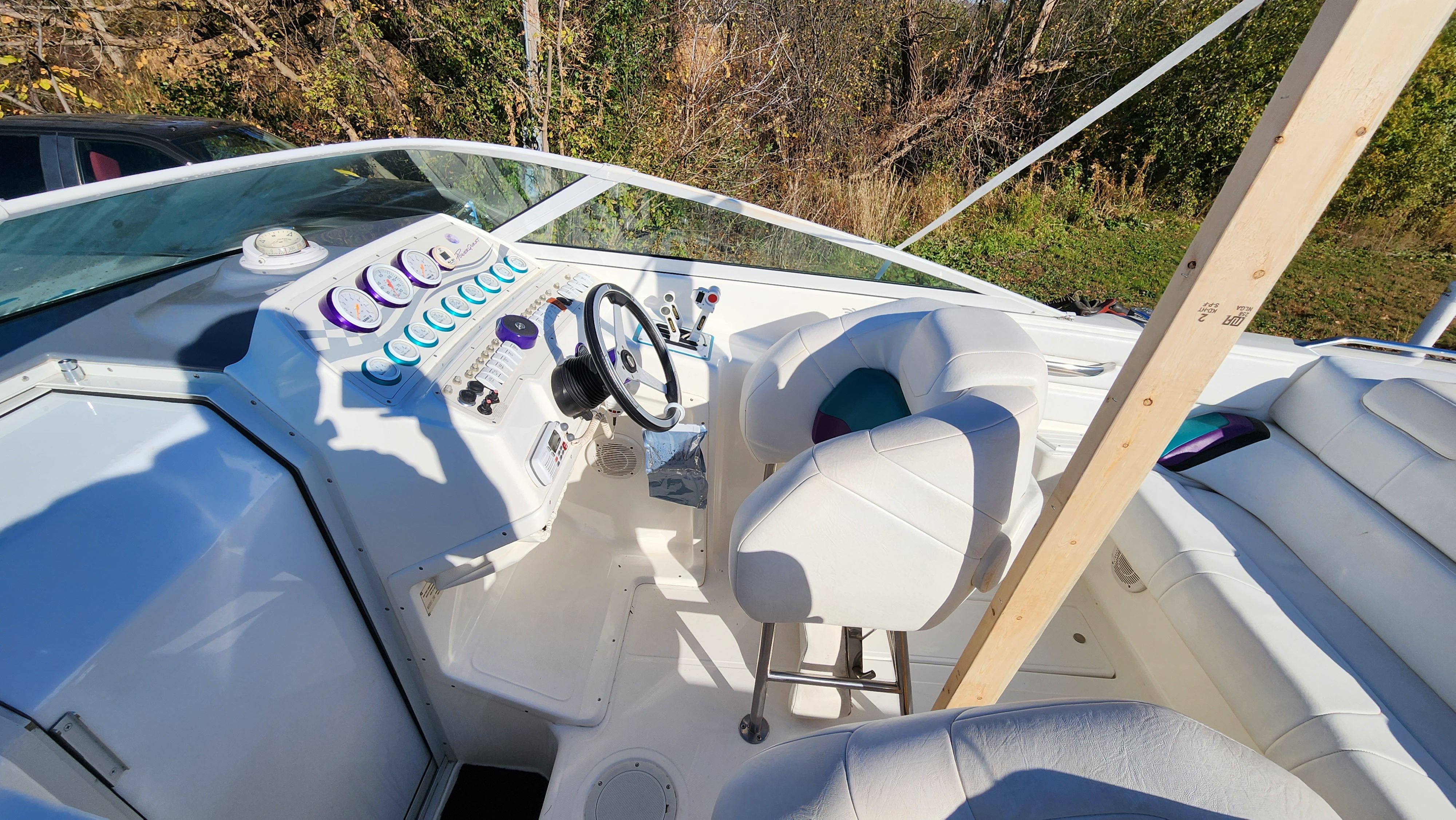 The cockpit of a 1998 Powerquest Enticer 290 FX with white seats and dashboard.