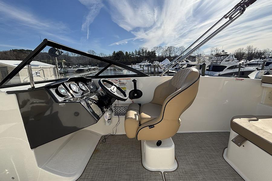 2023 Bayliner VR5 Bowrider OB cockpit with steering wheel and comfortable seating.