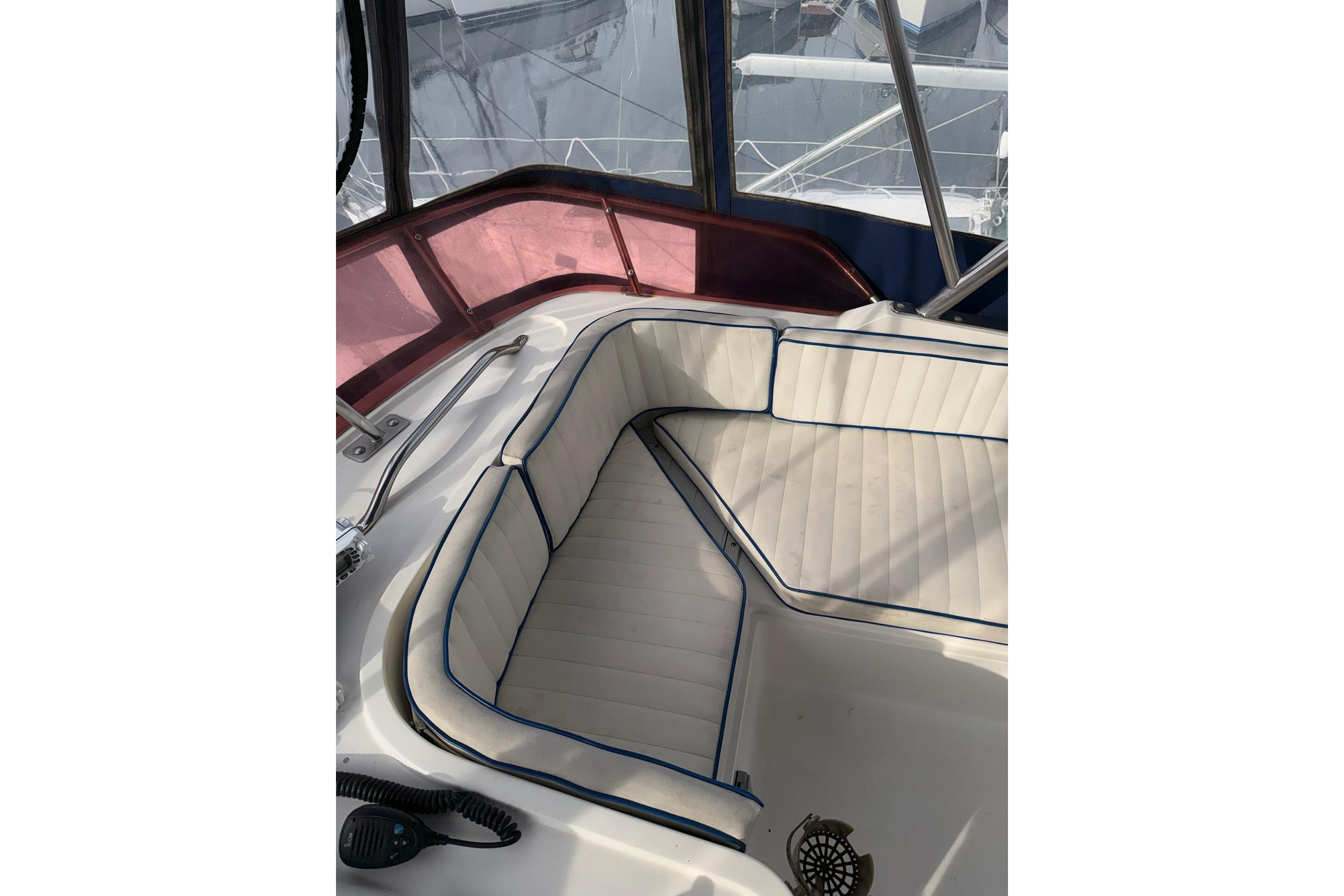 1990 Mediterranean Sport Fish boat interior with white cushioned seating and blue trim.