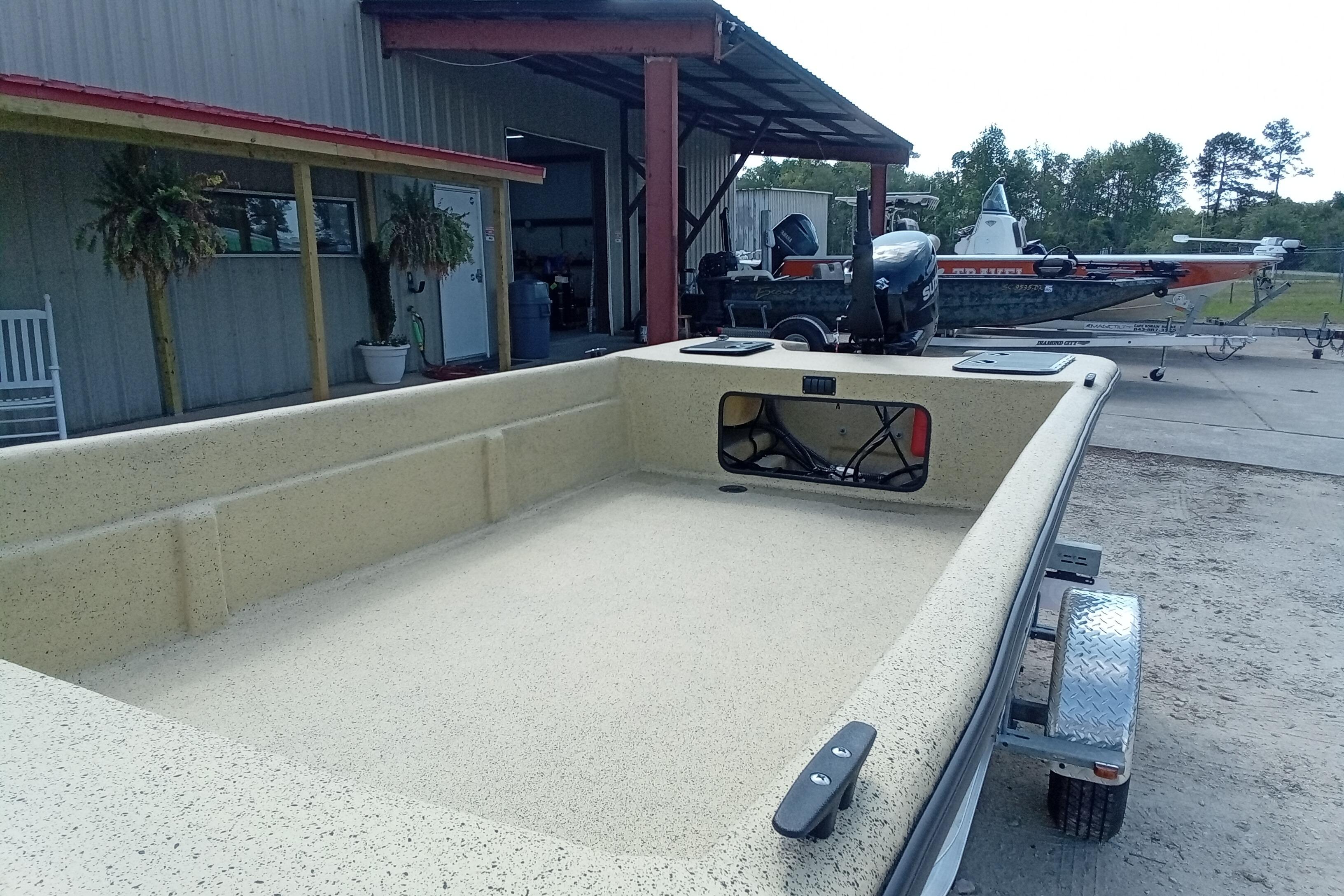 2025 Fibercraft F17 boat on trailer near a metal building.
