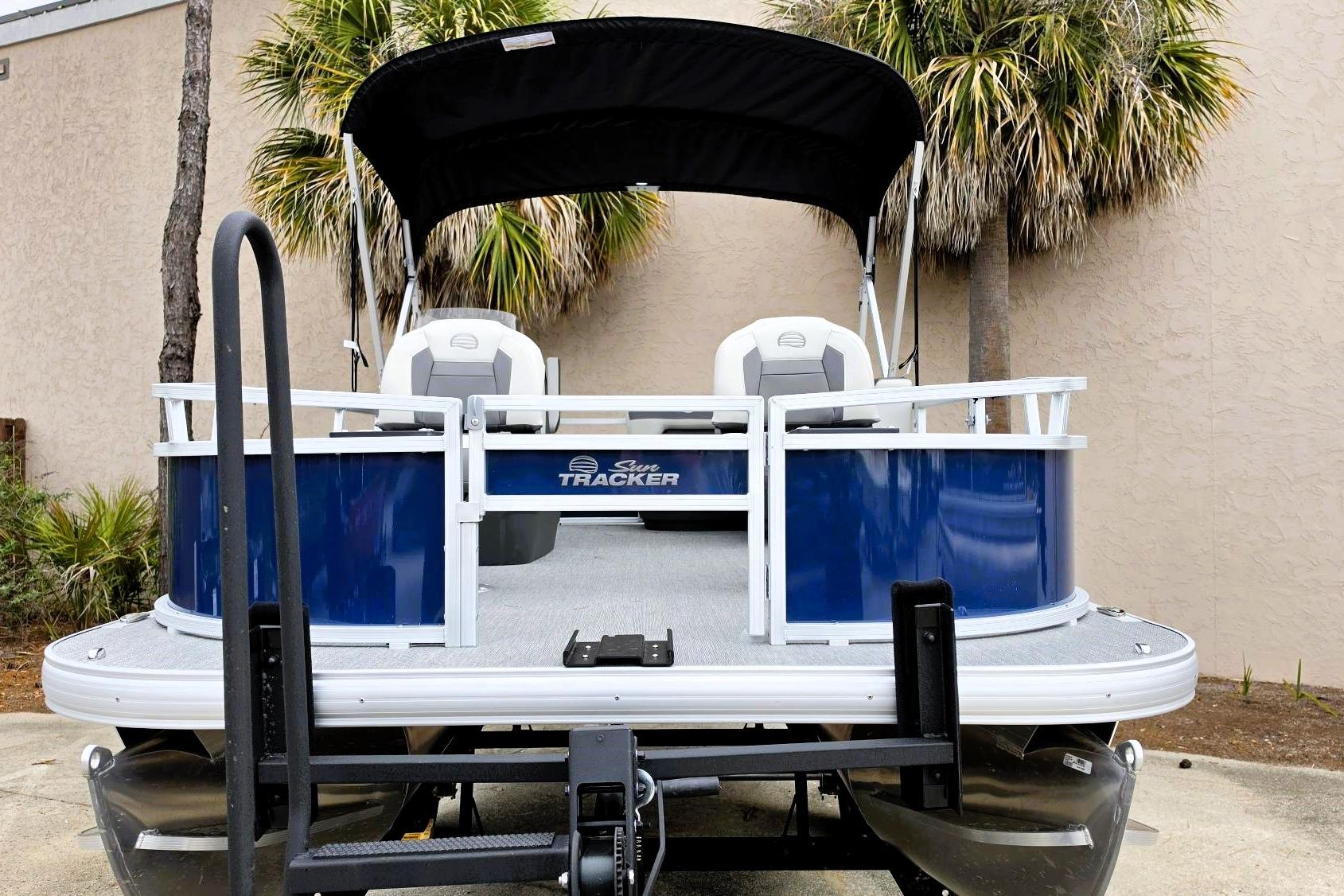 2026 Sun Tracker Bass Buggy 16 XL Select pontoon boat with canopy, parked outdoors.