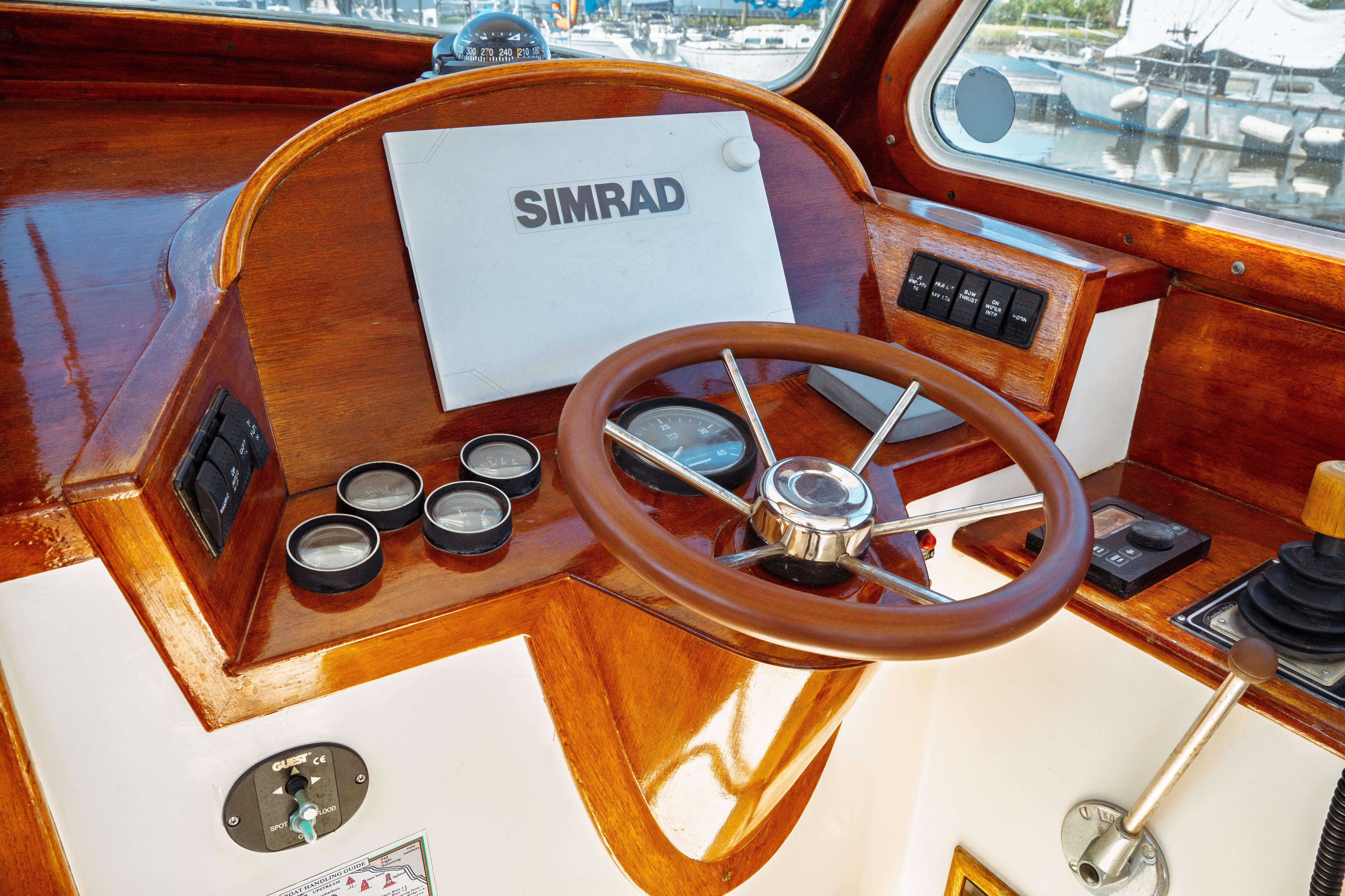 Helm of 2000 Hinckley Picnic Boat Classic with wooden steering wheel and Simrad display.