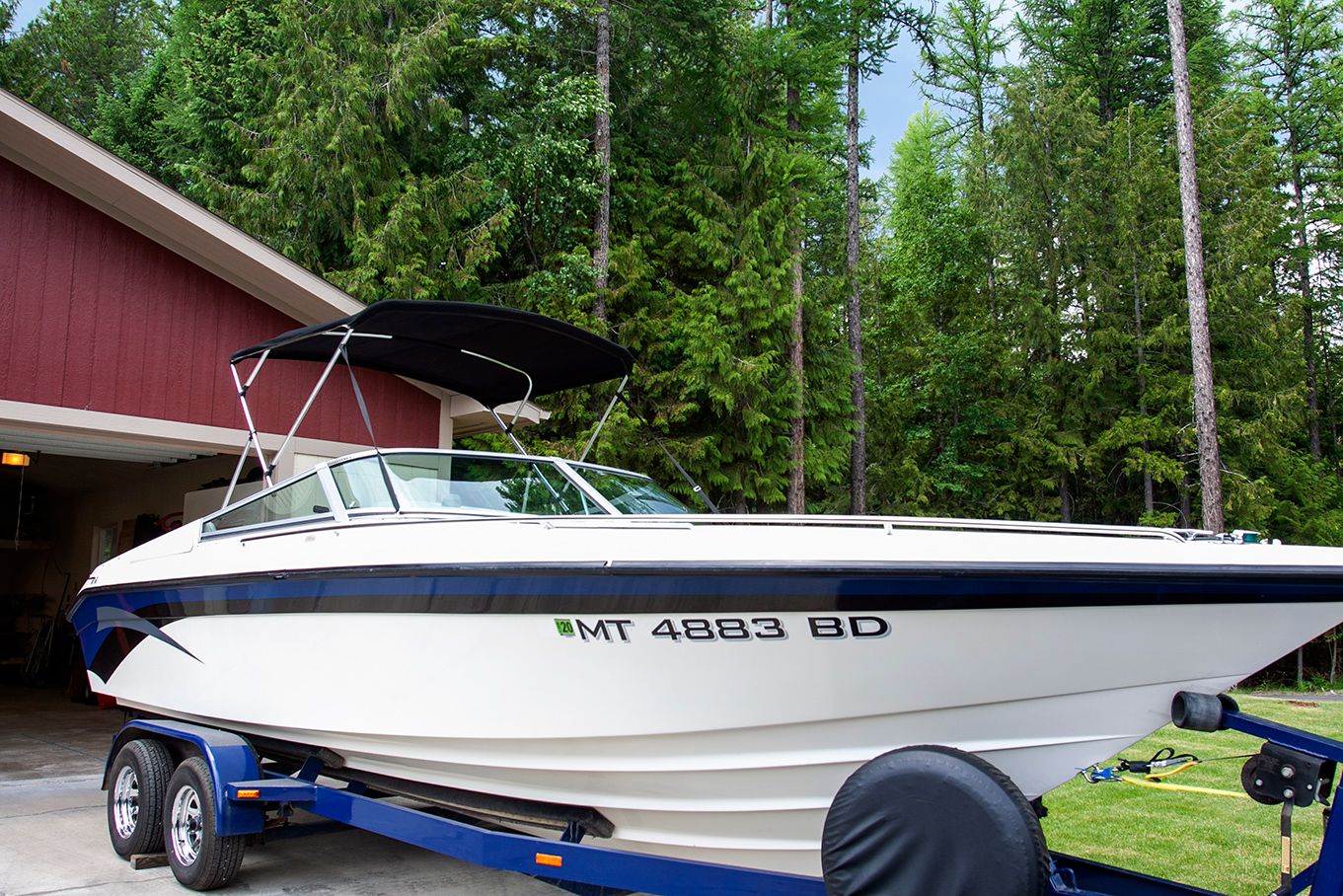 1995 Mirage Trovare 275 boat on trailer in front of garage.