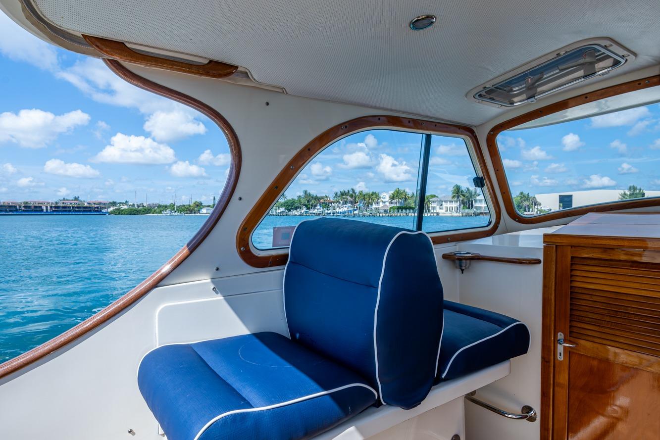 Interior view of 2001 Hinckley Picnic Boat Classic with blue seating and scenic water backdrop.