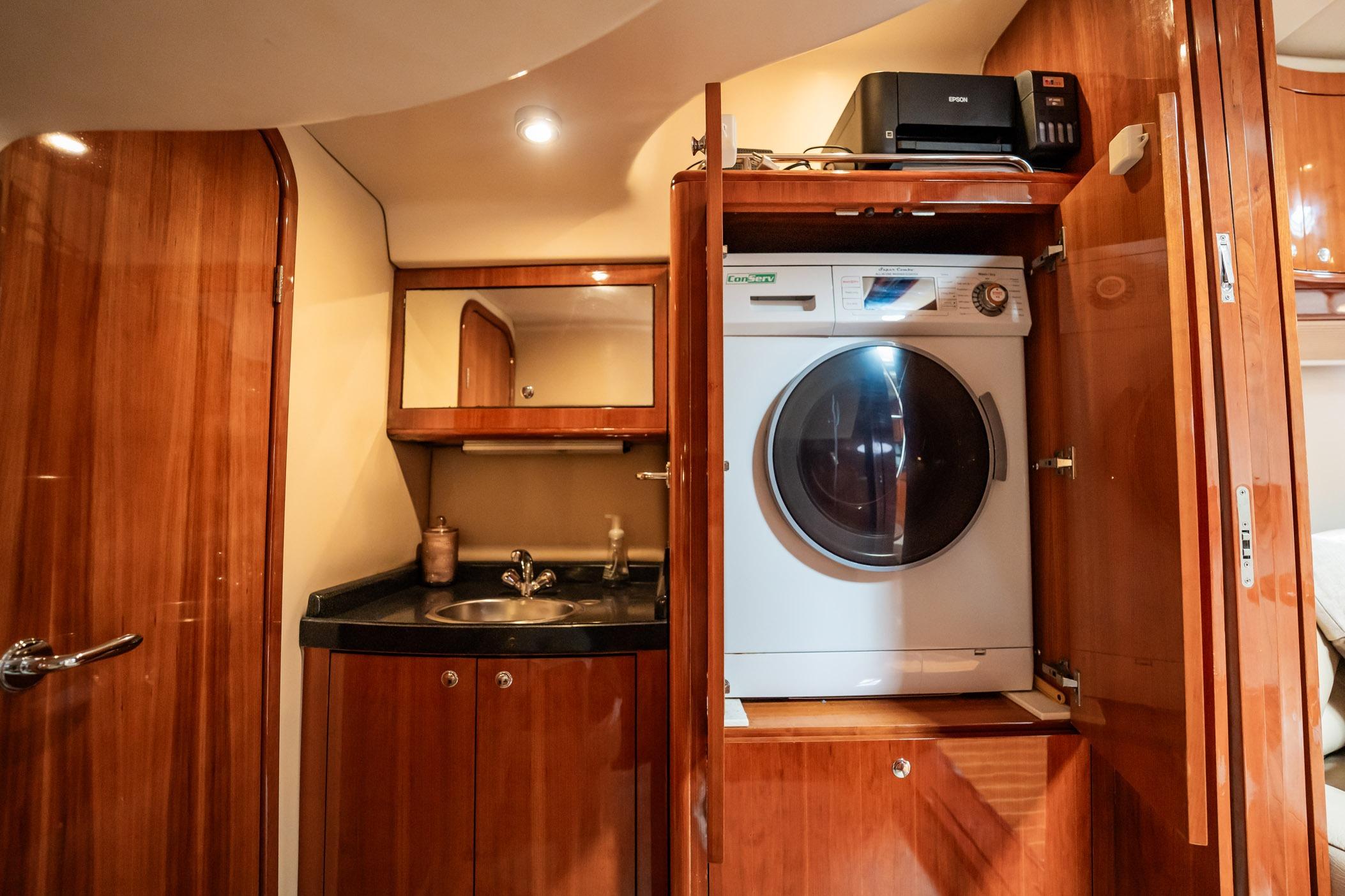 Luxurious 2008 Regal Commodore 4460 yacht interior with washer, sink, and wooden cabinetry.