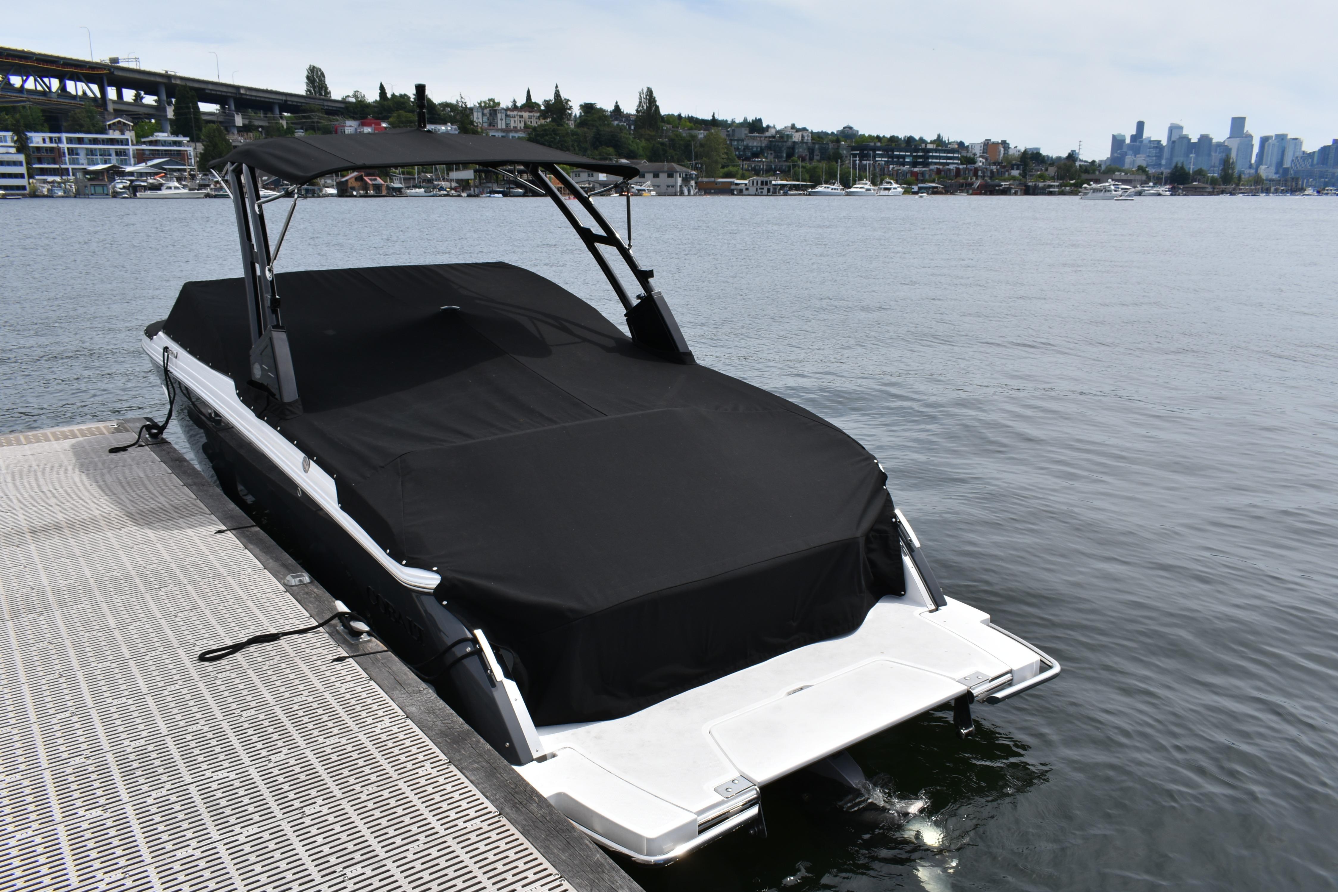 2023 Cobalt R8 boat docked with cover, city skyline in background.