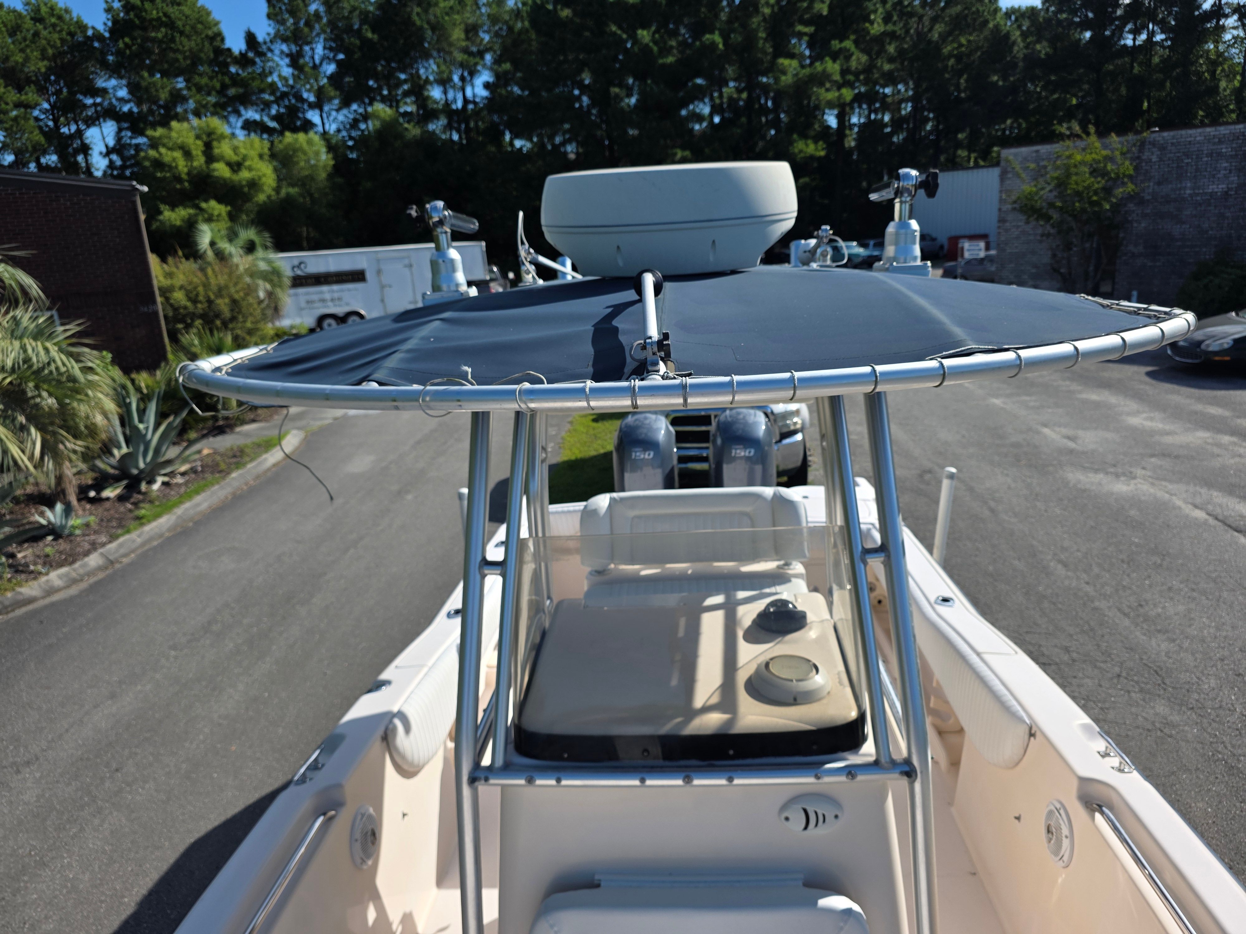 A 2006 Grady-White 257 boat with a blue sunshade and two outboard motors.