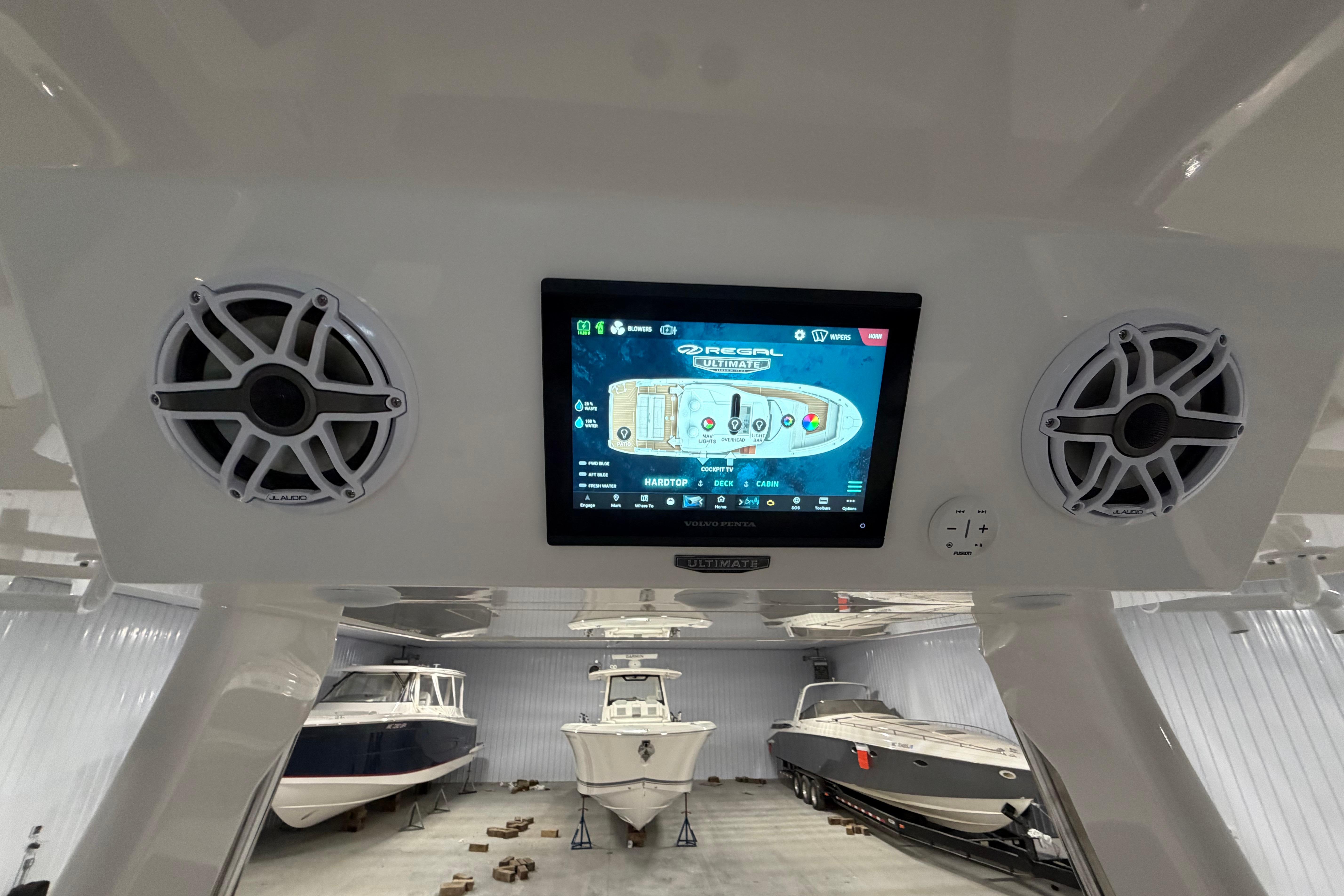 2027 Regal 38 Surf boat dashboard with touchscreen and speakers in a storage facility.