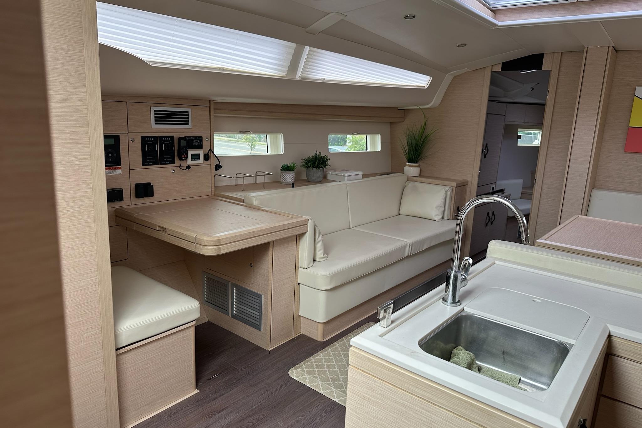 Luxurious interior of a 2018 Jeanneau 51 yacht with modern kitchen and seating area.