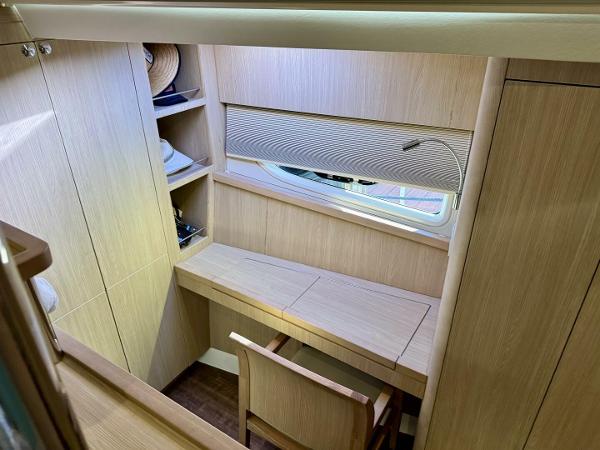 2022 Aquila 44 yacht interior with wooden desk, chair, and shelves.