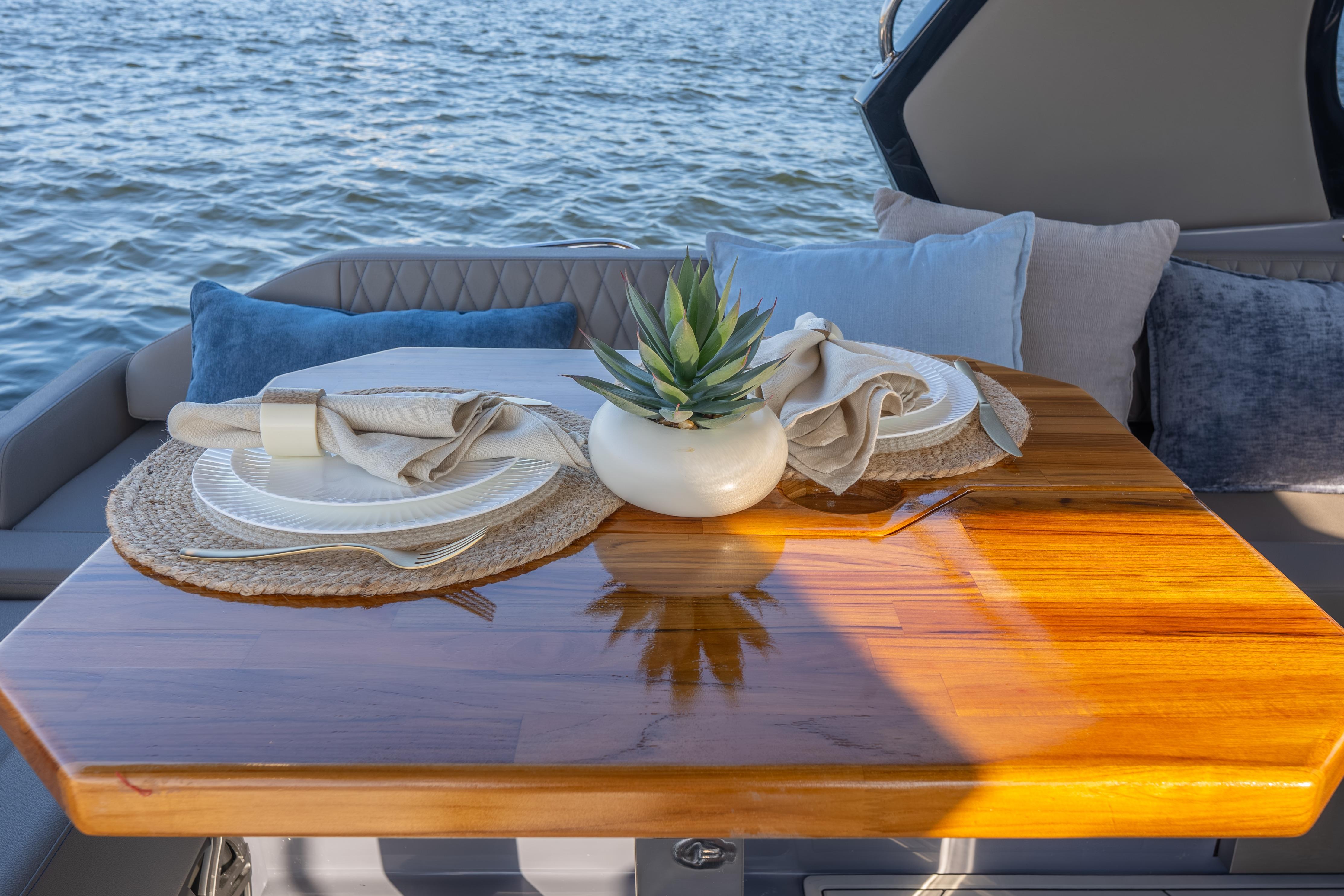 Luxurious Hanover 347 yacht dining setup with elegant tableware and cushions, 2026 model.