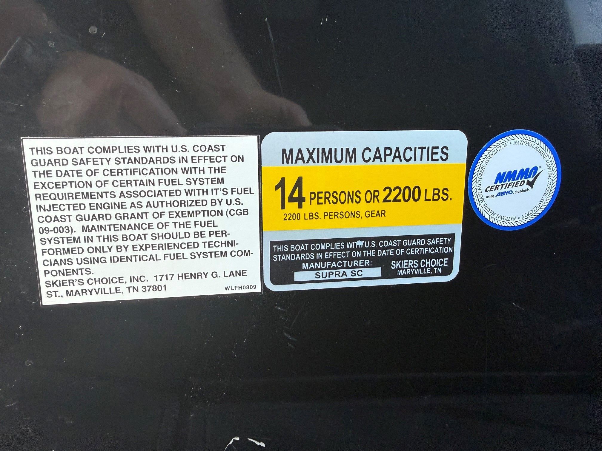 Sign displaying safety and capacity information for a boat, including maximum persons and weight.