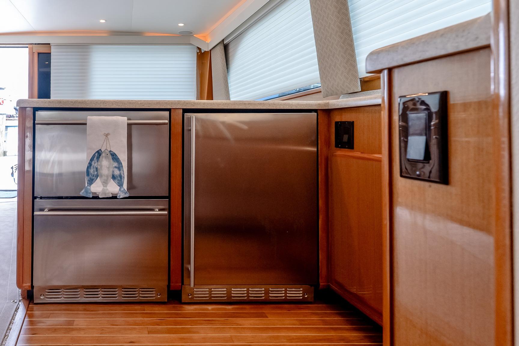 Modern kitchen area on a 2000 Viking 50' Convertible yacht with stainless steel appliances.