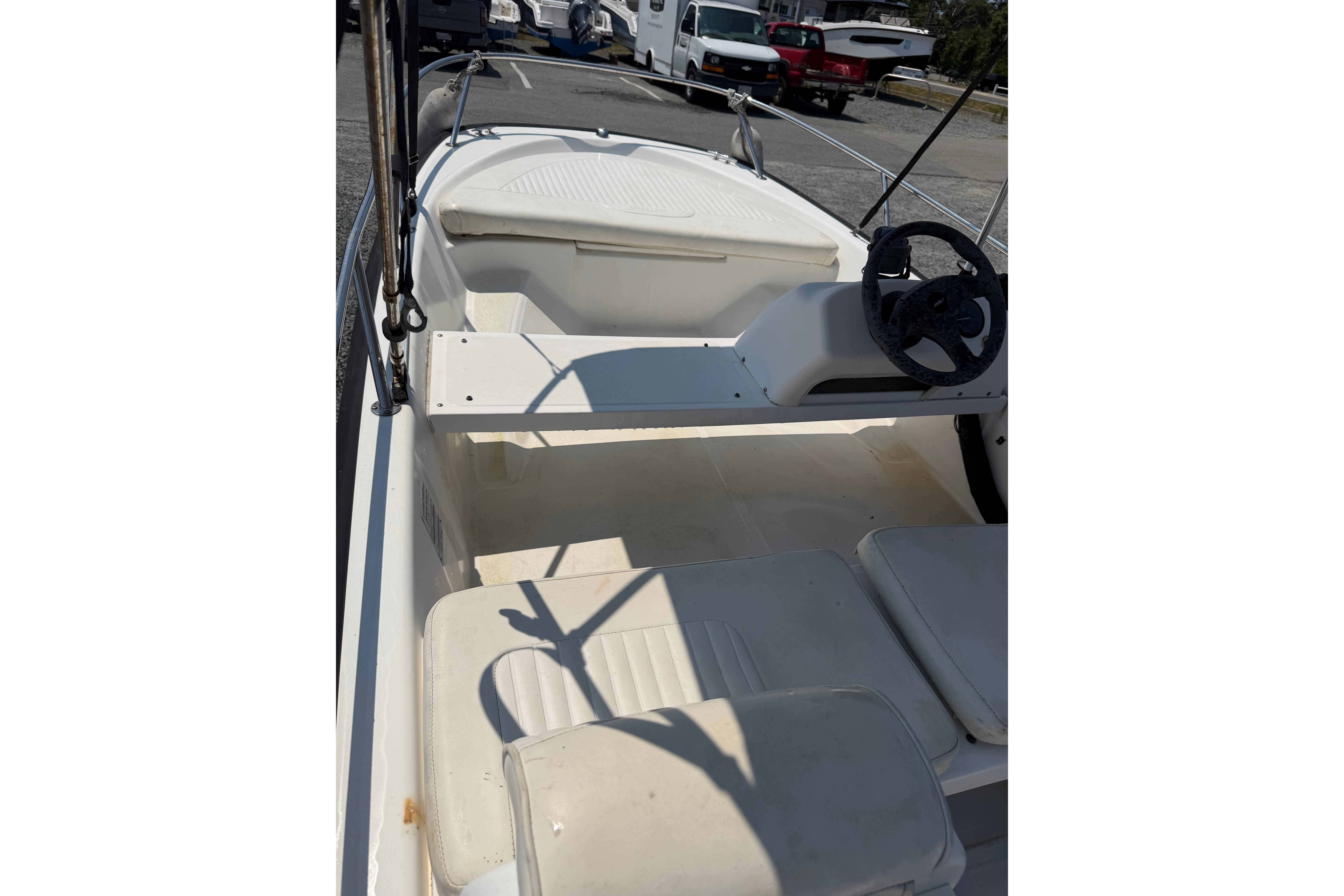 2003 Boston Whaler 130 Super Sport interior with steering wheel and seating.