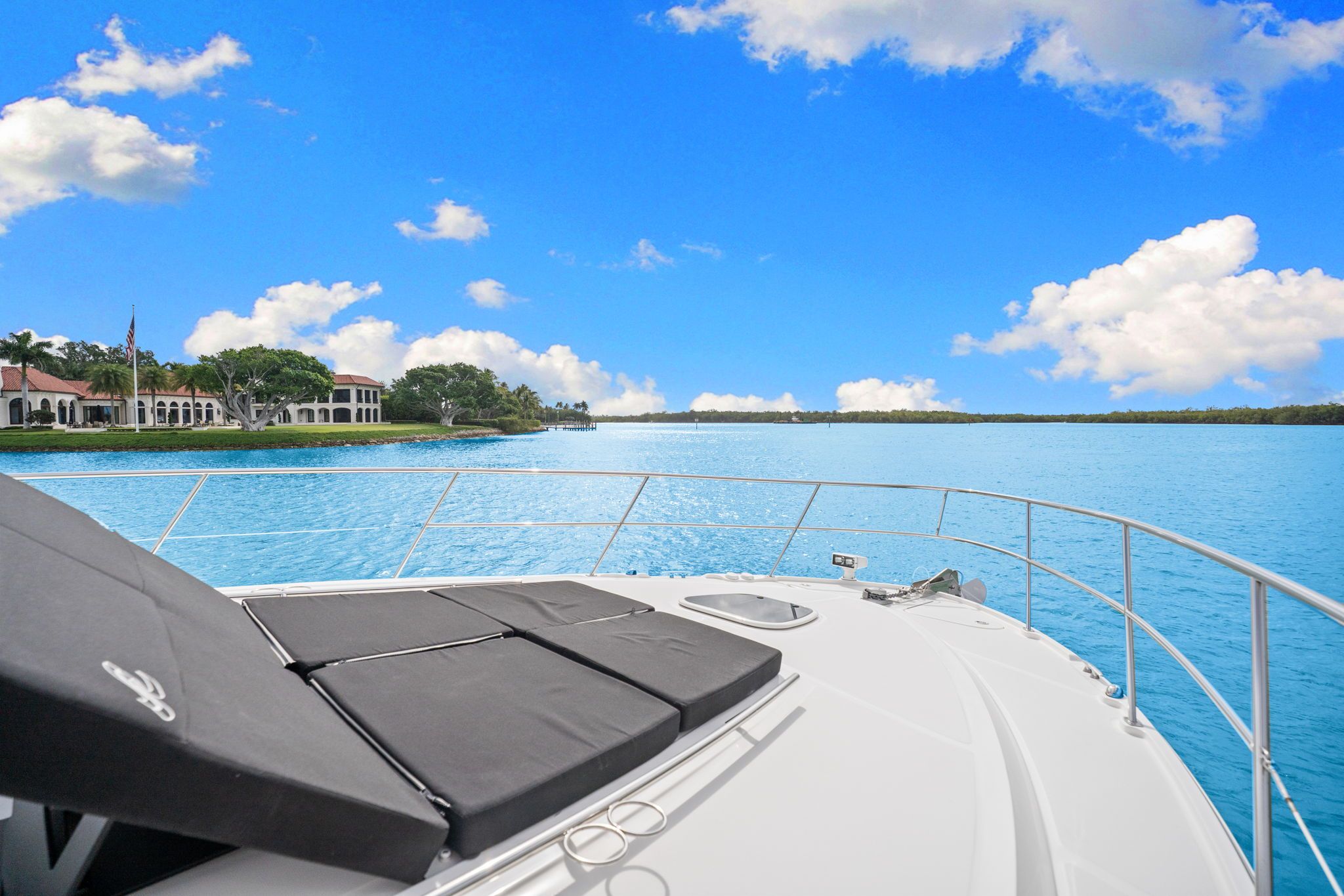 The deck of a 2017 Sea Ray Sundancer 510 overlooking calm blue water and a cloudy sky.