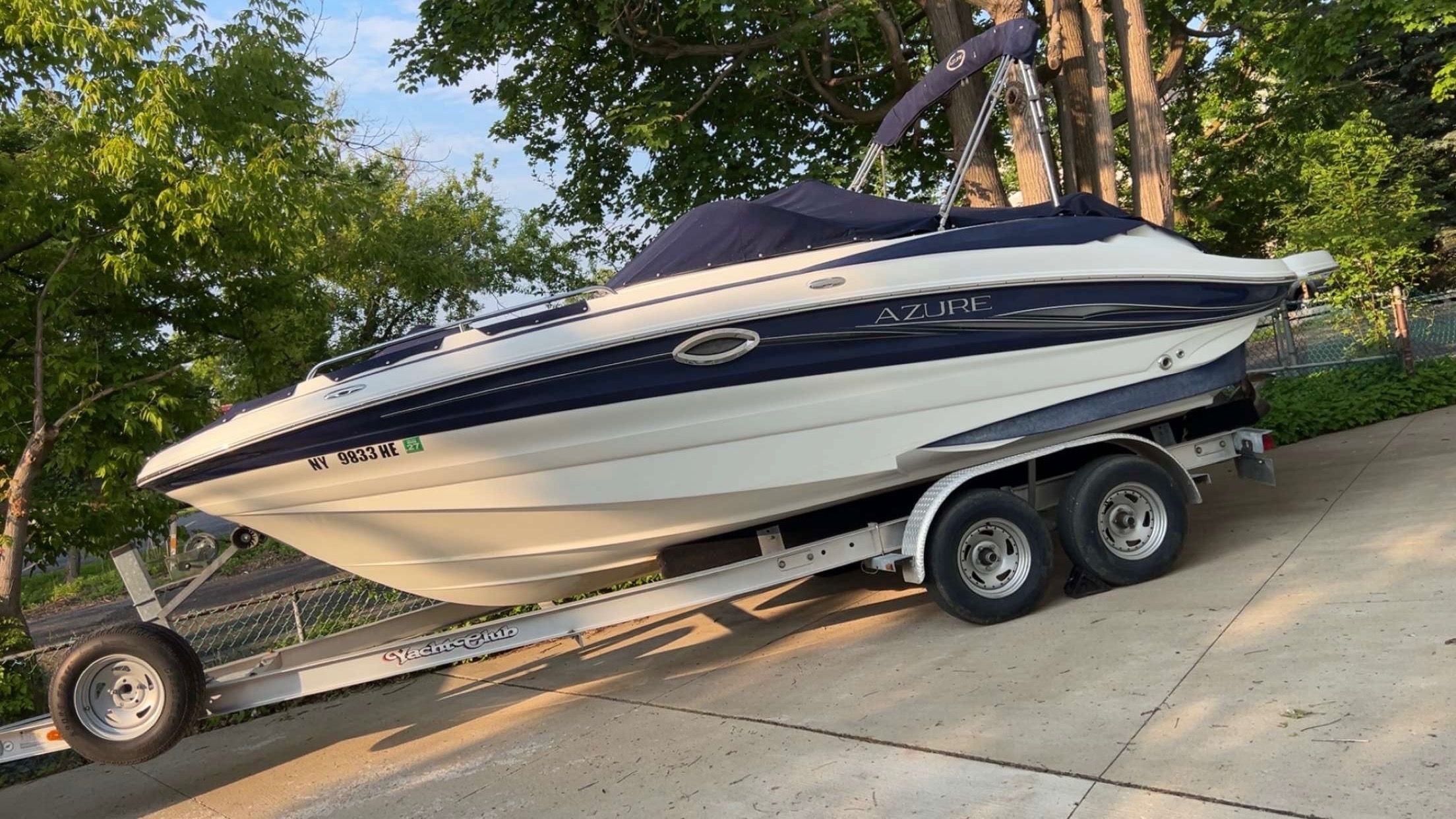 A white and blue Azure boat, model AZ220, year 2008, is on a trailer.