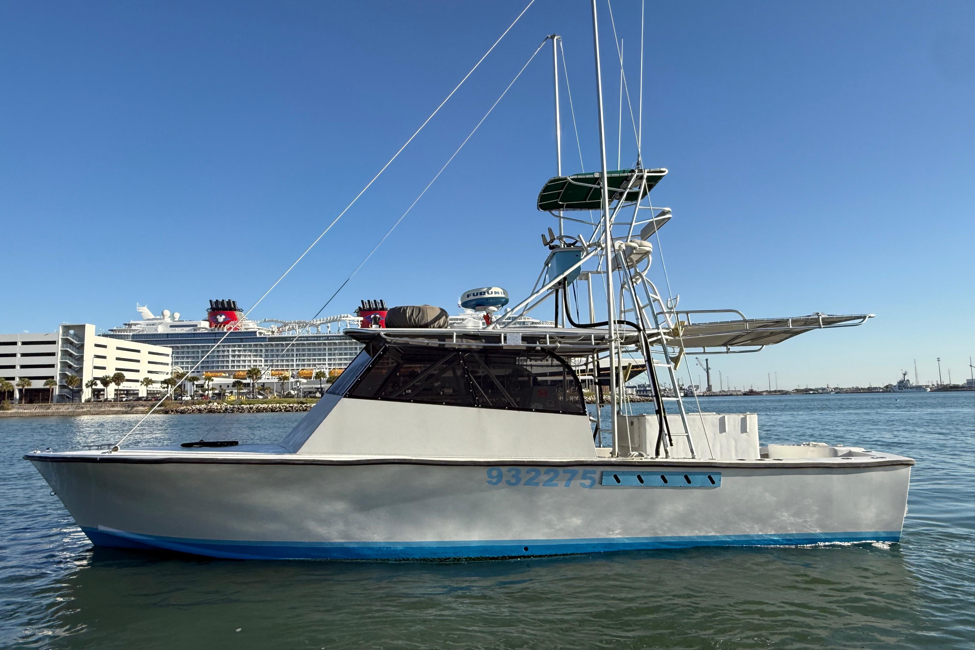 1988 Stuart Angler 32 boat on water with cruise ship in background.