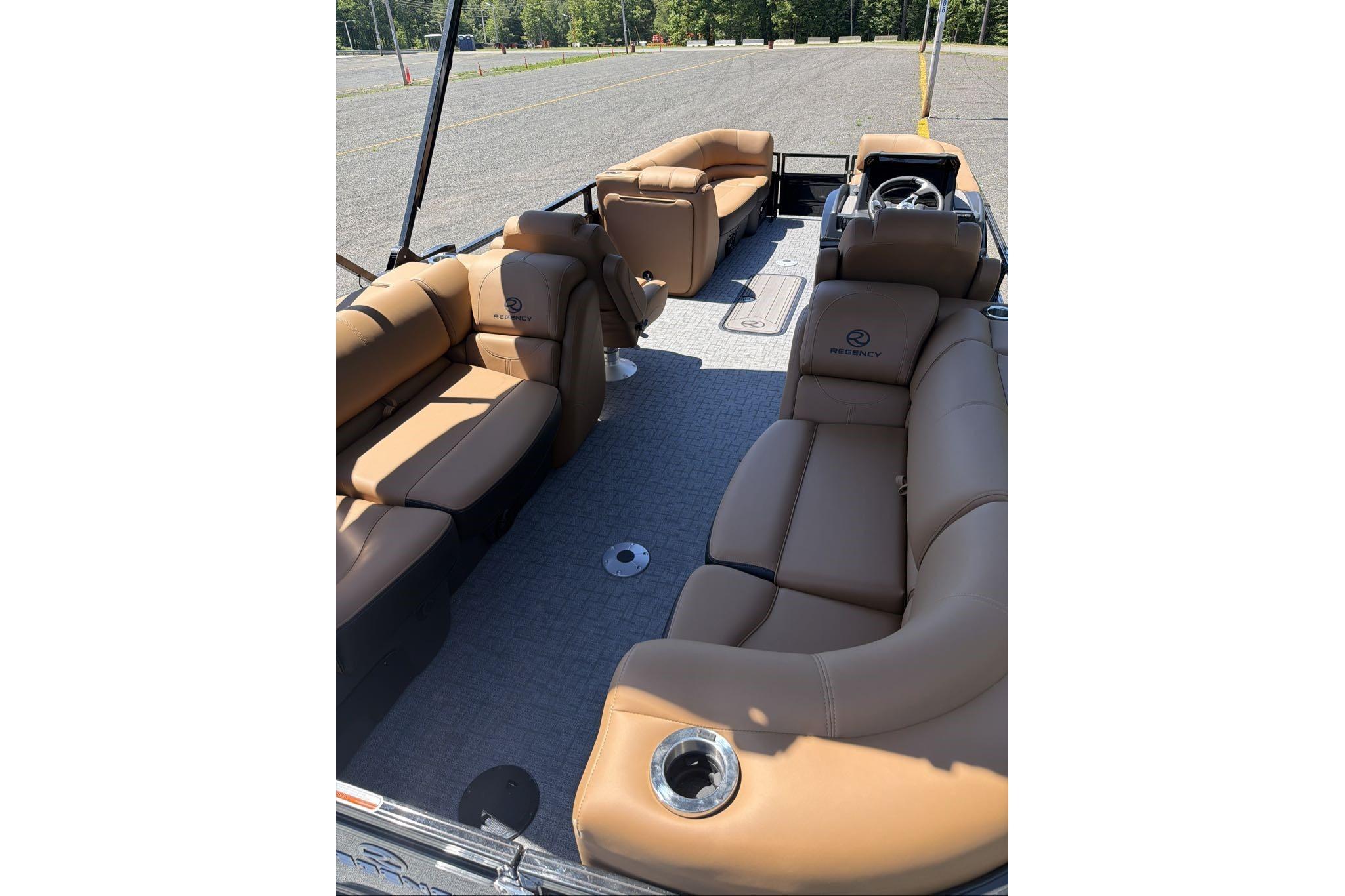 Luxurious 2026 Regency 230 DL pontoon boat with spacious tan seating and modern design.