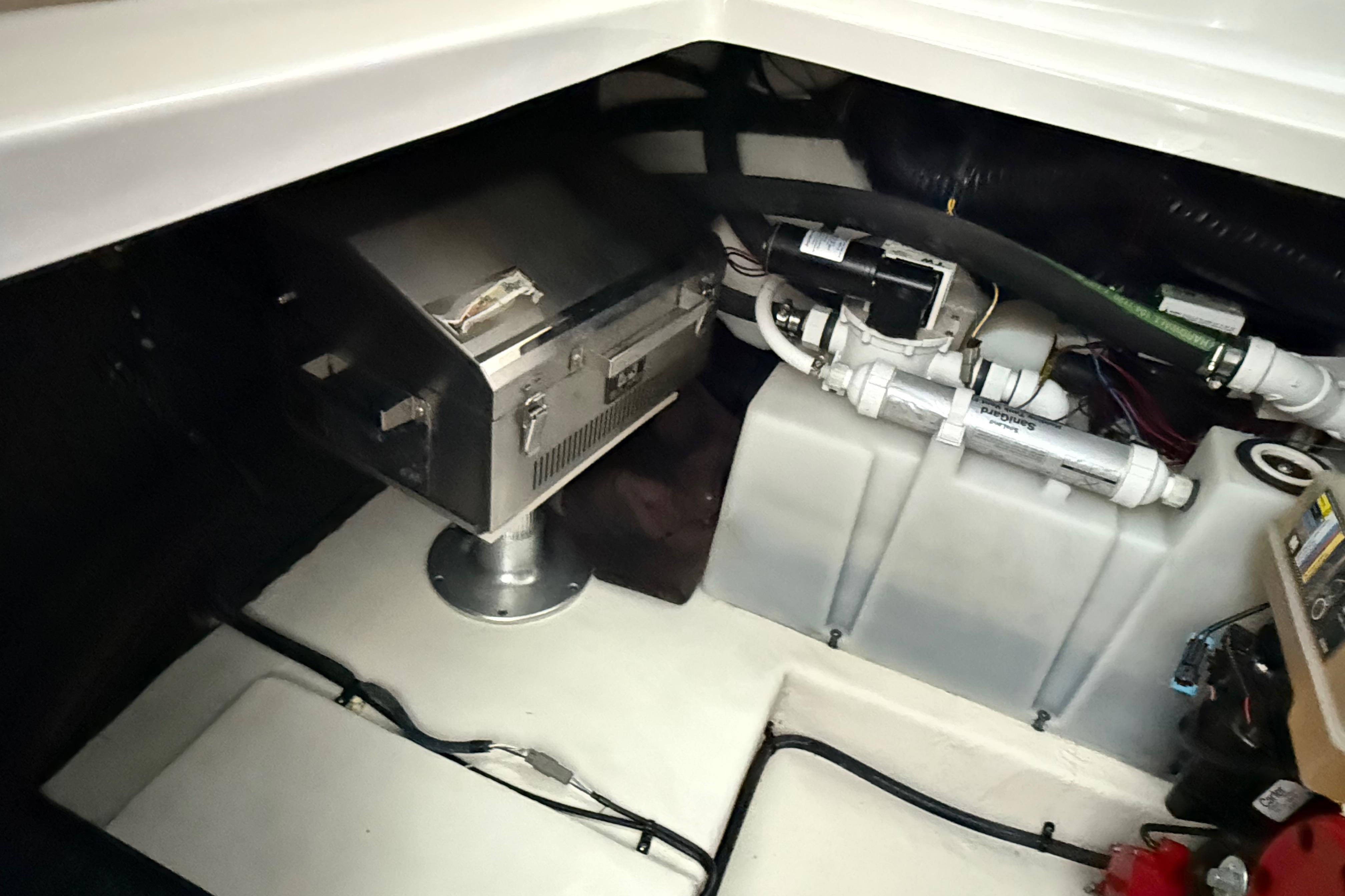 Engine compartment of 2016 Chaparral 290 Signature boat, featuring mechanical components and wiring.